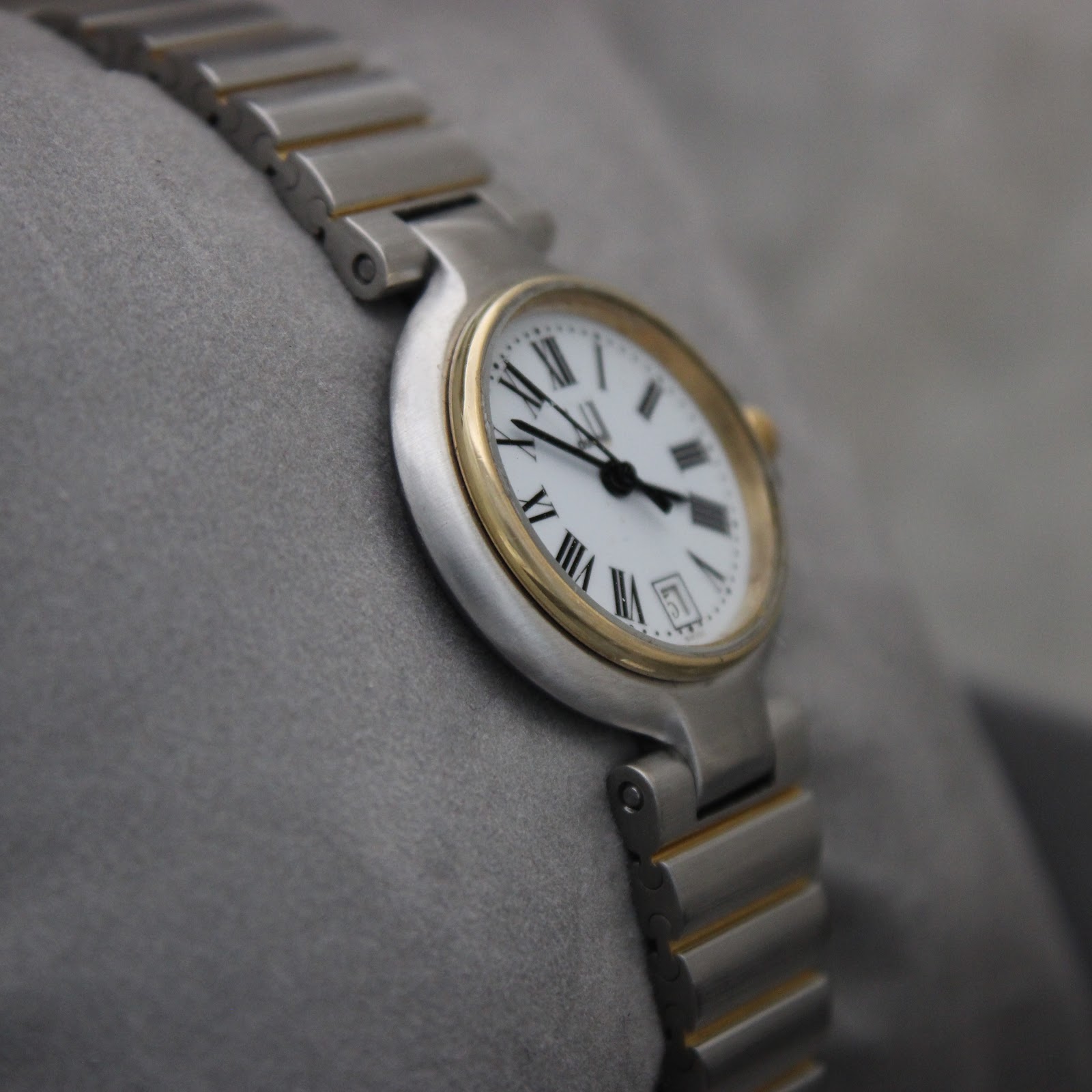 Another angled view of the Dunhill watch, highlighting the white dial and two-tone bracelet.