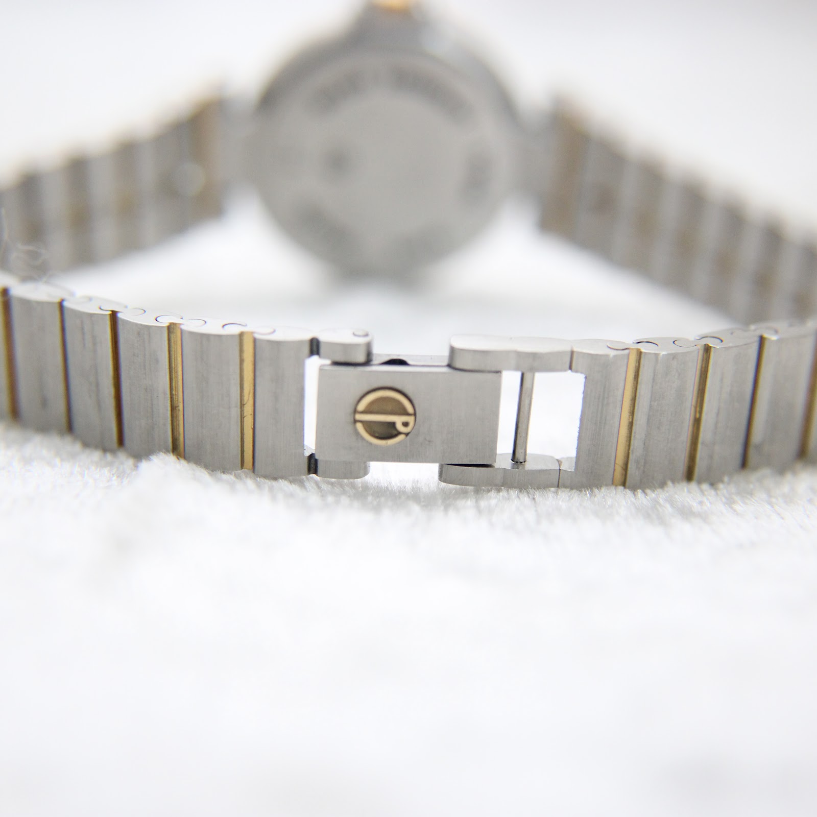 Close-up of the two-tone bracelet deployment clasp with the Dunhill logo.