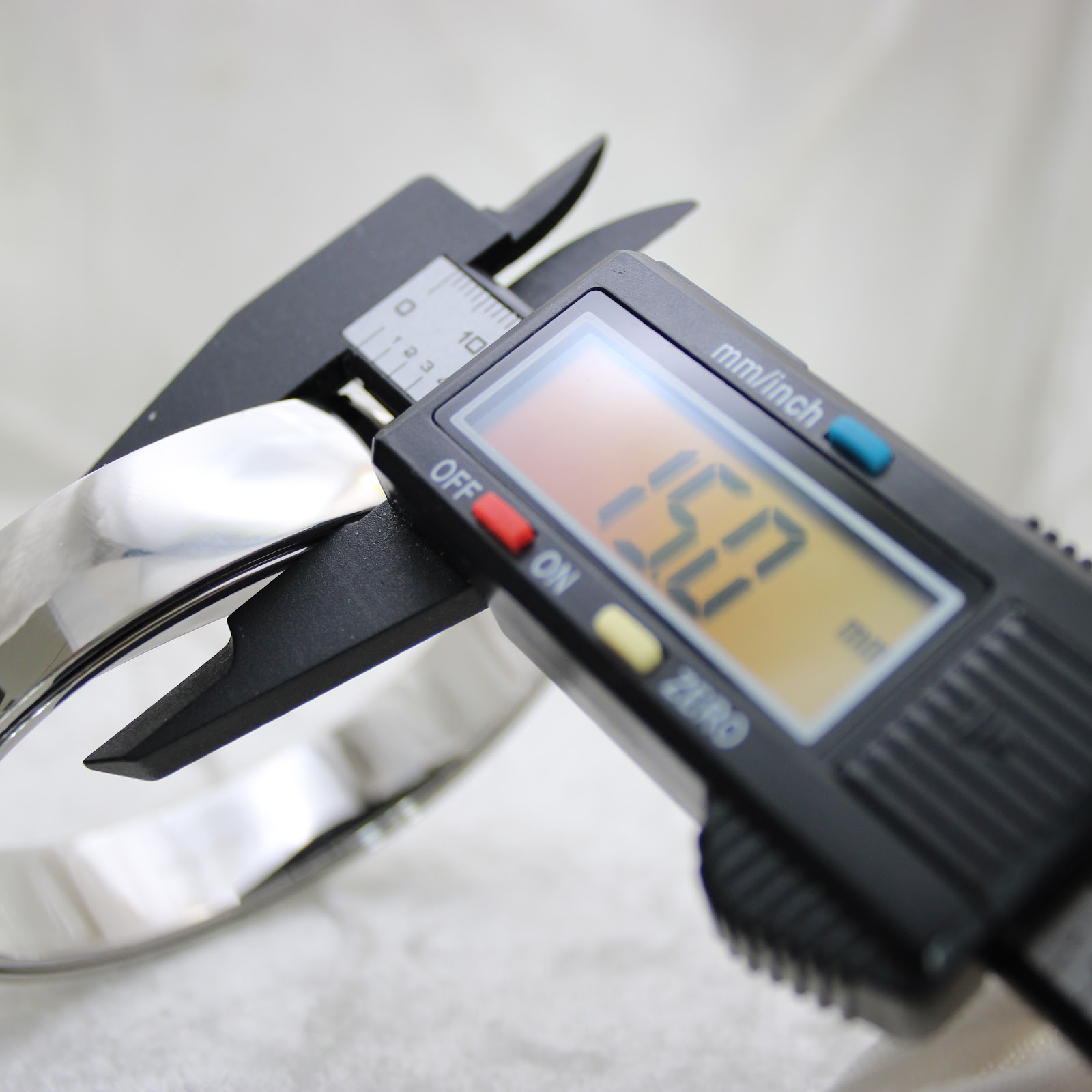 Digital caliper display reading 150.0 mm, measuring the internal circumference of the watch's integrated bangle bracelet.