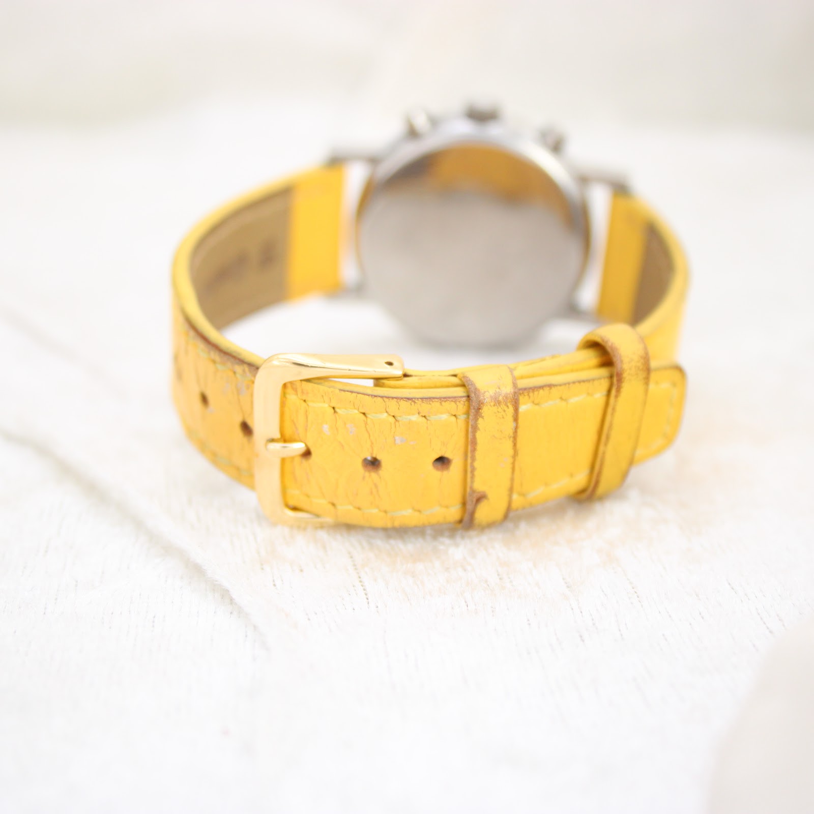 Close-up of the yellow leather strap and gold-tone buckle of the Mercedes-Benz SLK watch.