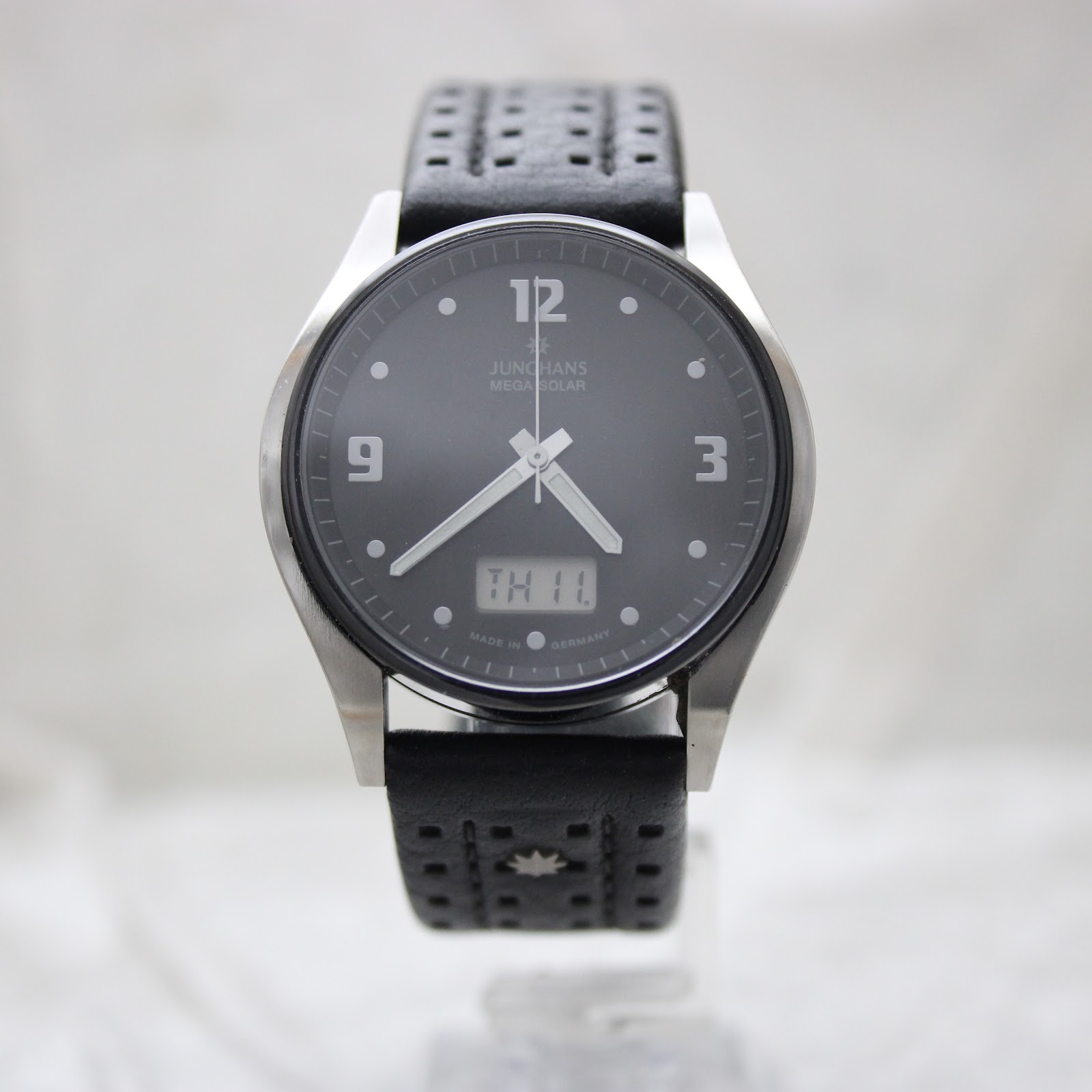 Straight-on front view of the Junghans Mega Solar watch with its black dial, showing day 'TH' and date '11'.