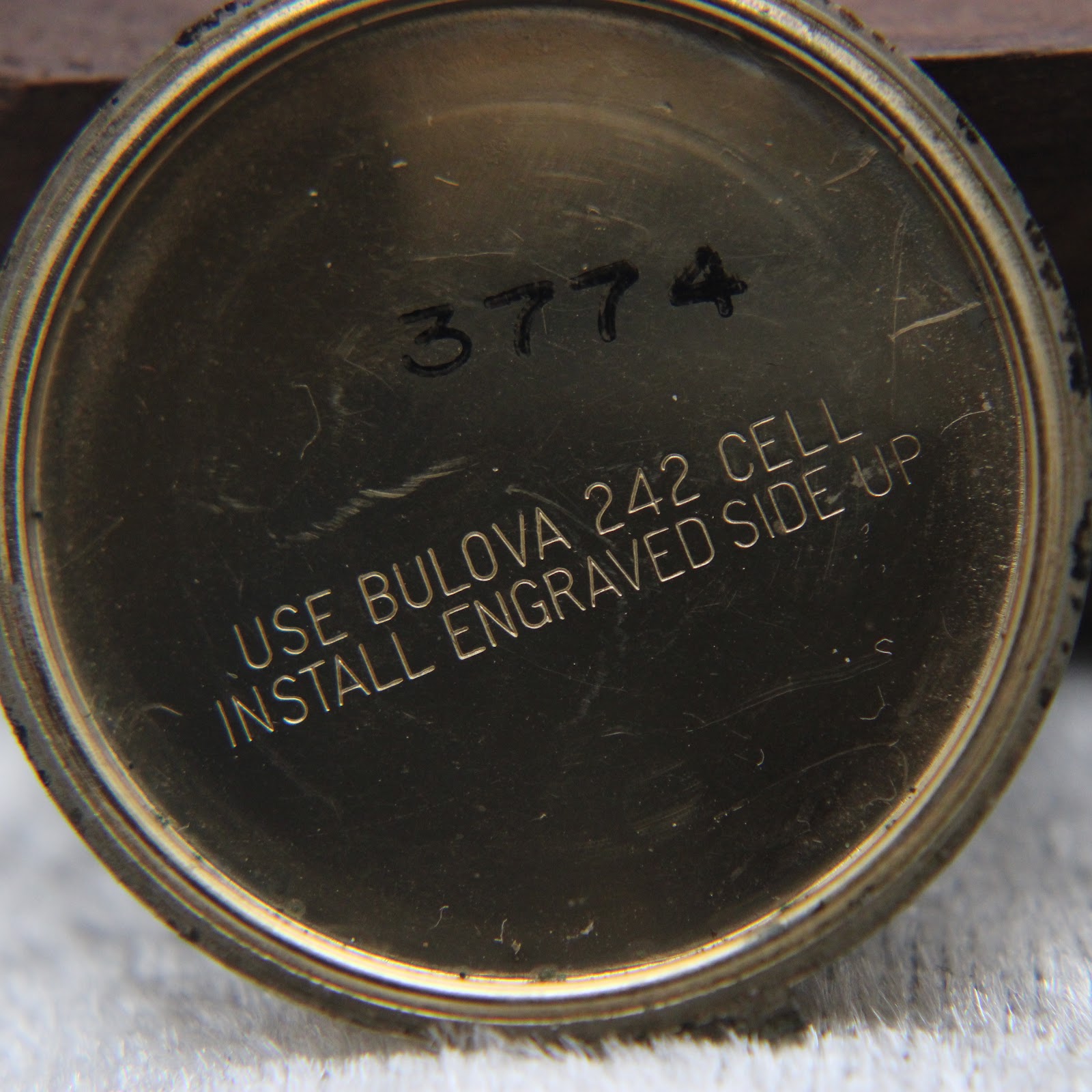 Interior view of the case back, showing instructions for battery installation and a serial number "3774".