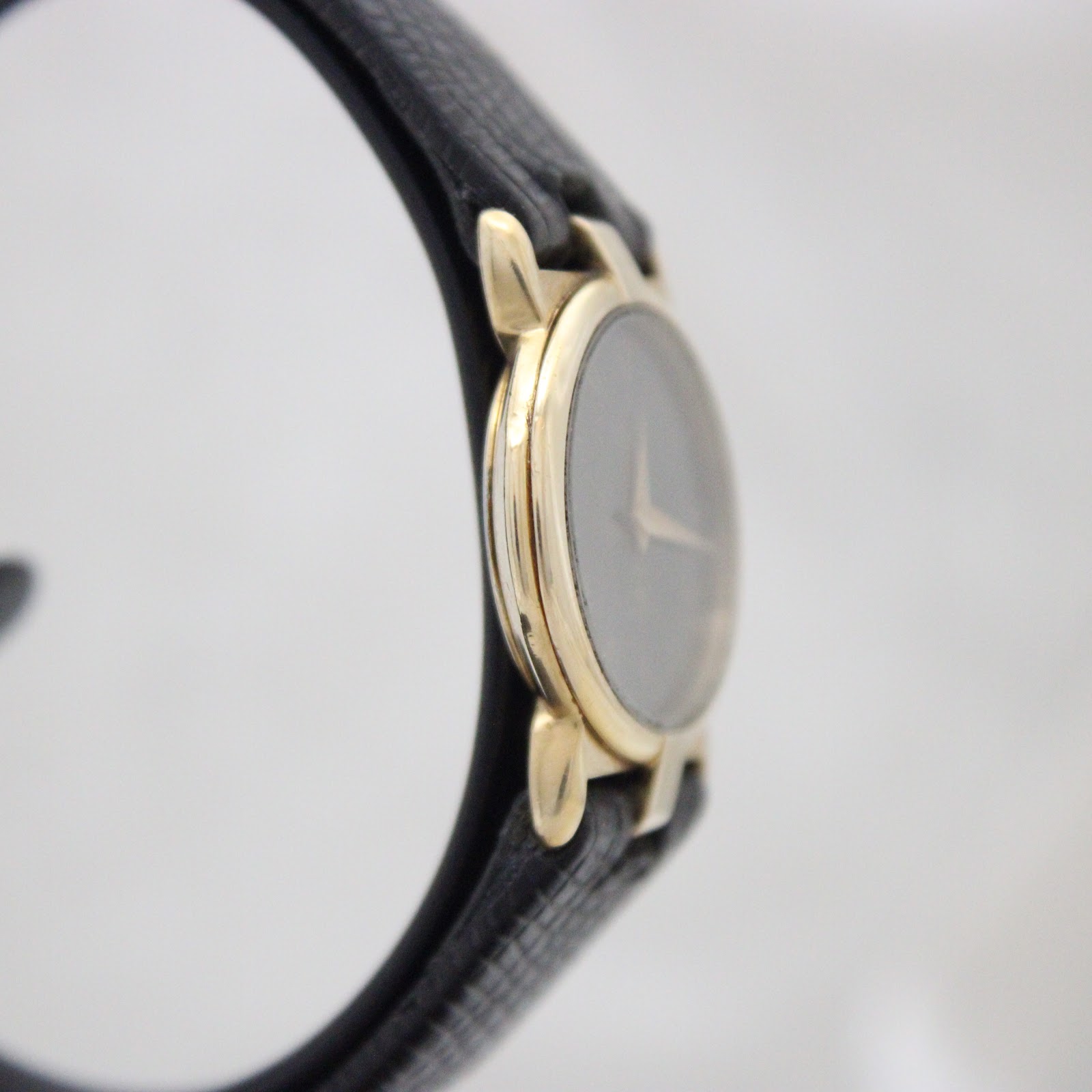 Another side profile view of the gold-plated Gucci case, showing its slim design.