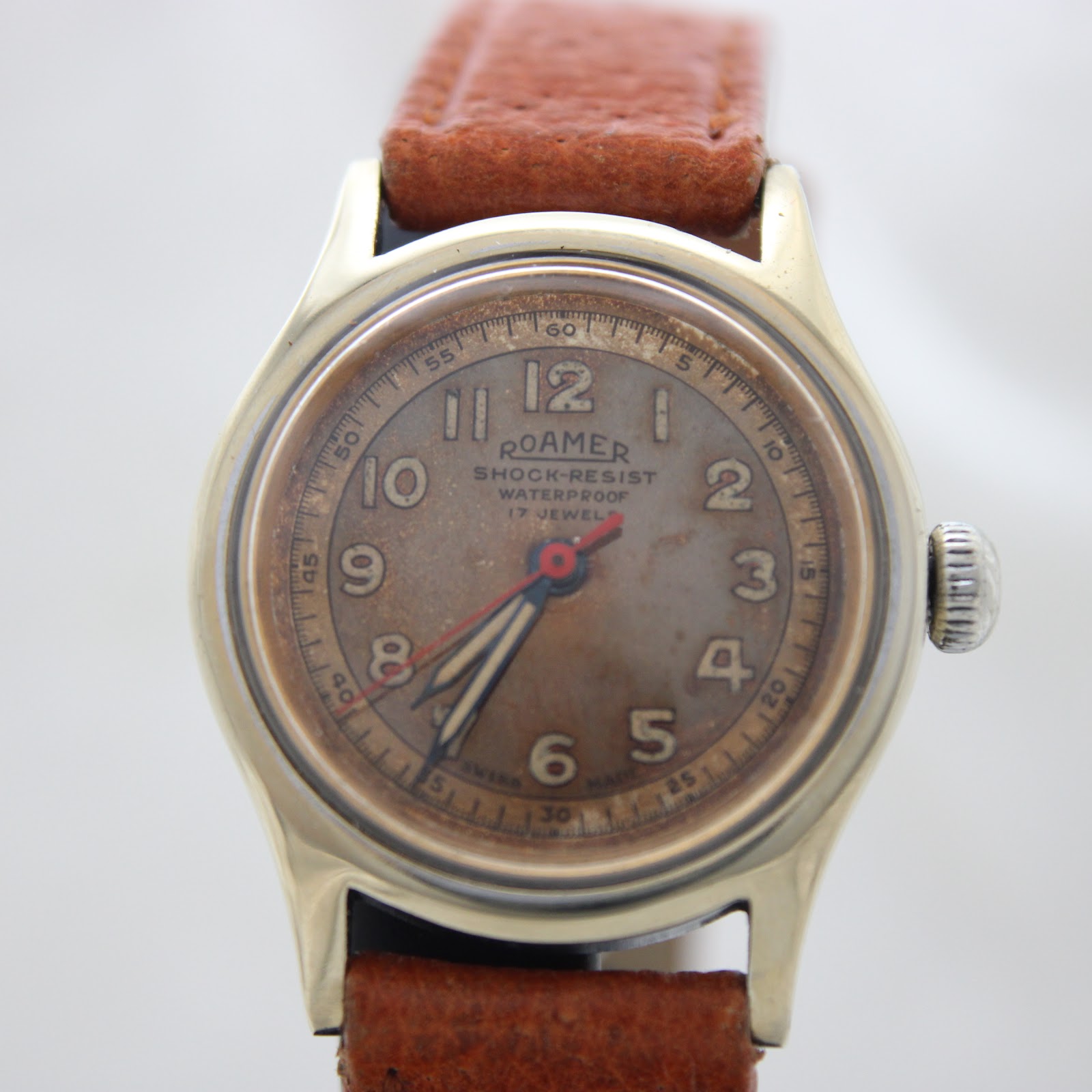 Slightly angled front view of the Roamer watch, highlighting the domed acrylic crystal and gold-tone case.