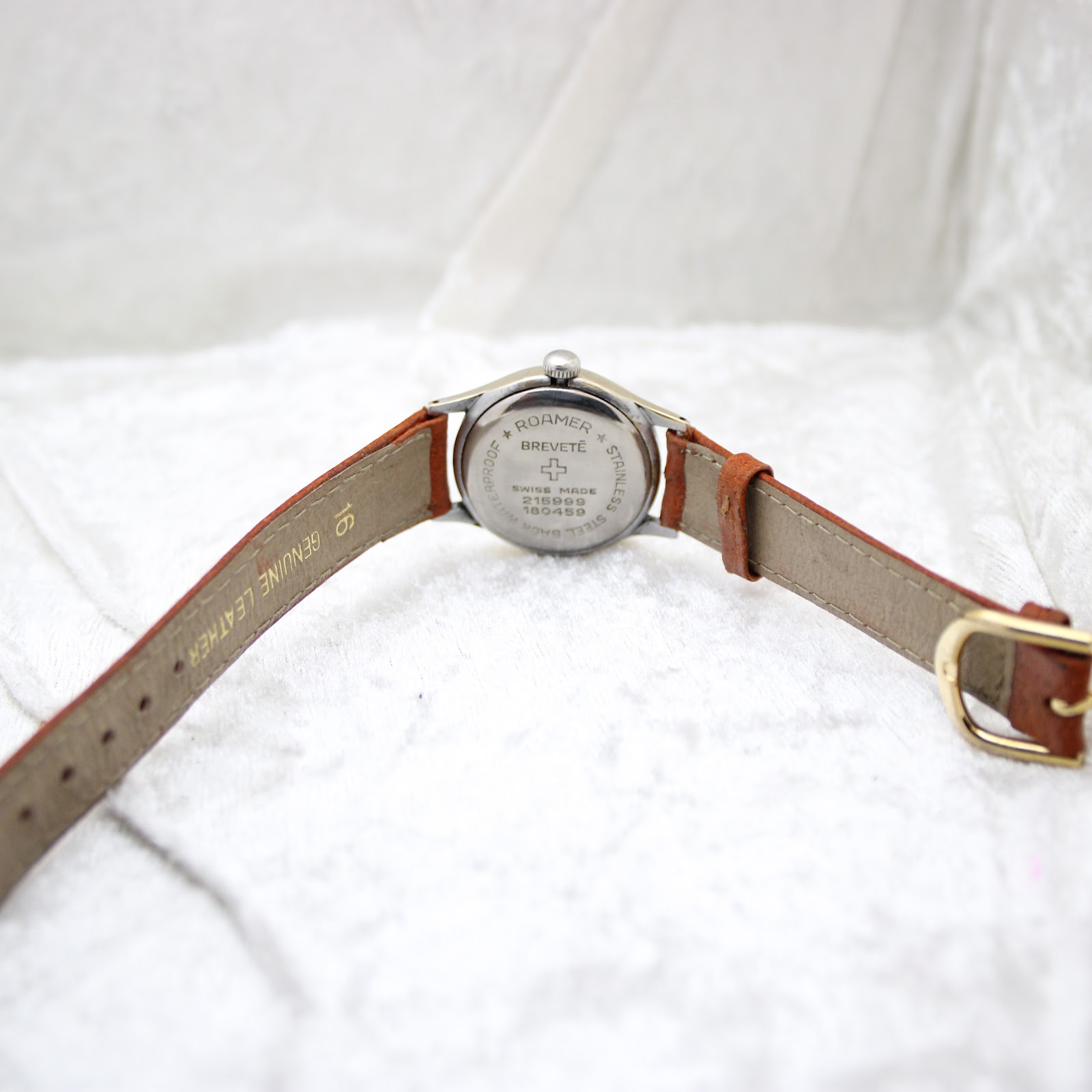 Underside of the brown leather strap, indicating 'GENUINE LEATHER' and the 18mm lug width.