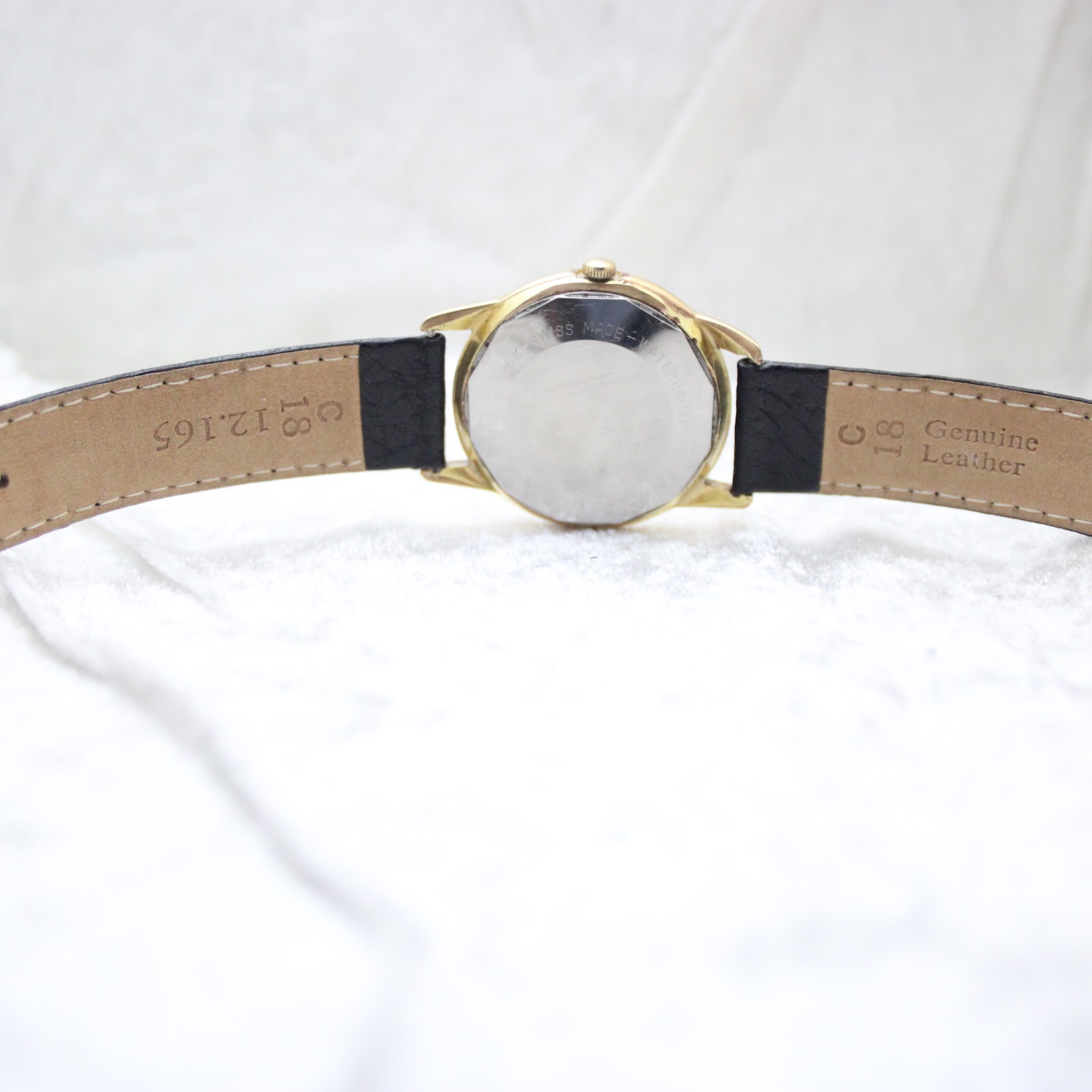Back view of the Aristocrat watch showing the stainless steel case back and the black leather strap with 'Genuine Leather' embossed.
