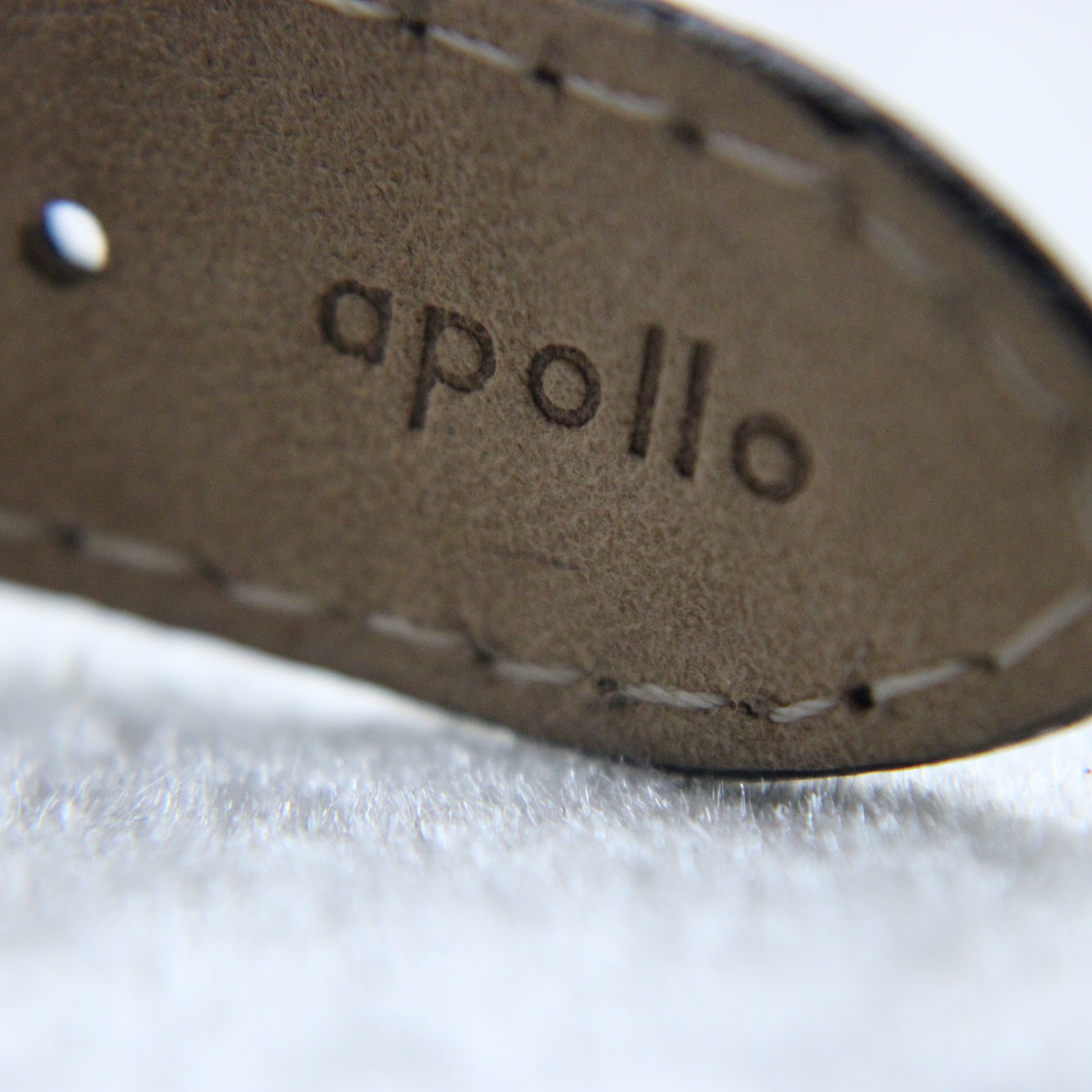 Close-up of the 'Apollo' embossing on the inside of the black leather strap.