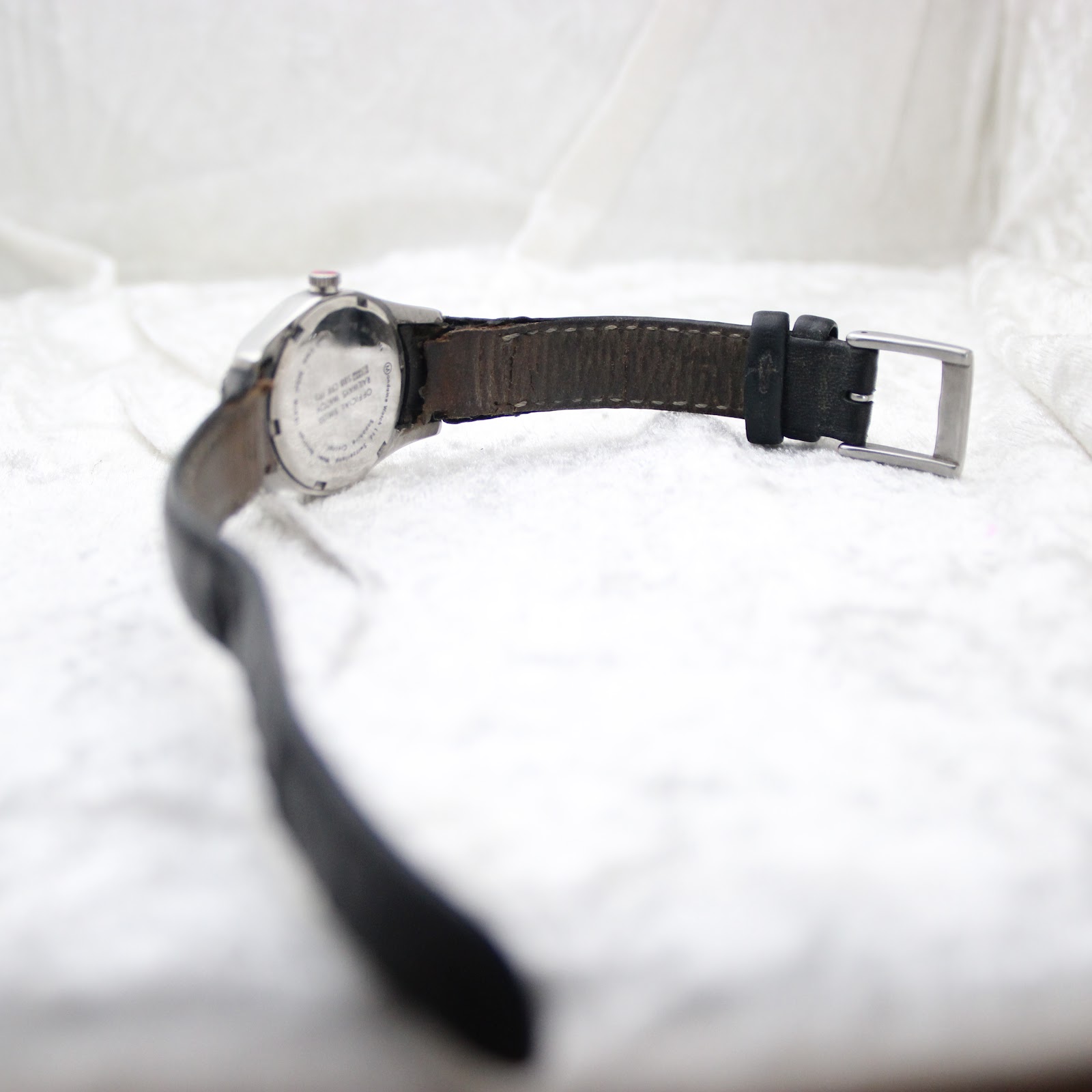 Angled view of the Mondaine watch from the back, showing the strap and buckle
