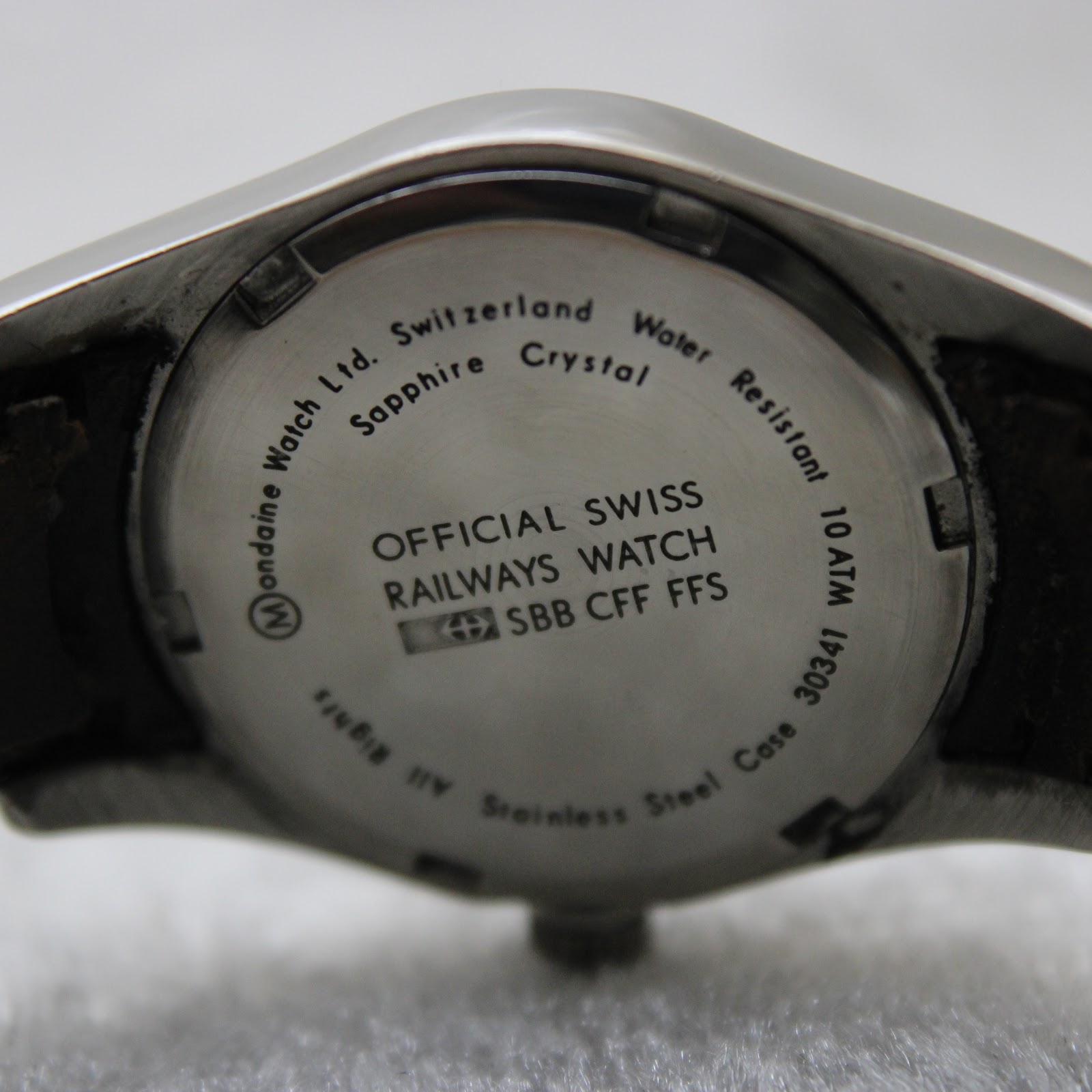 Close-up of the stainless steel case back with engravings: "OFFICIAL SWISS RAILWAYS WATCH SBB CFF FFS", "Sapphire Crystal", "Water Resistant 10 ATM", "Stainless Steel Case"