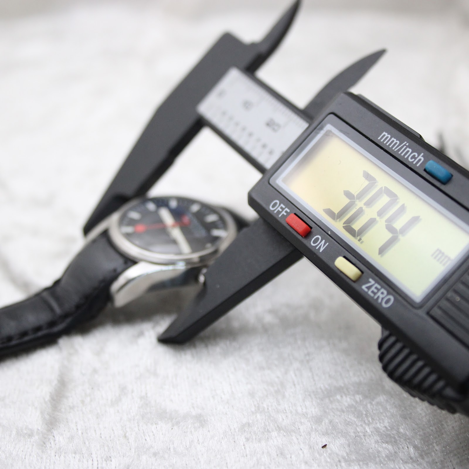 Digital caliper measuring the case diameter of the Mondaine watch, showing 30.4mm