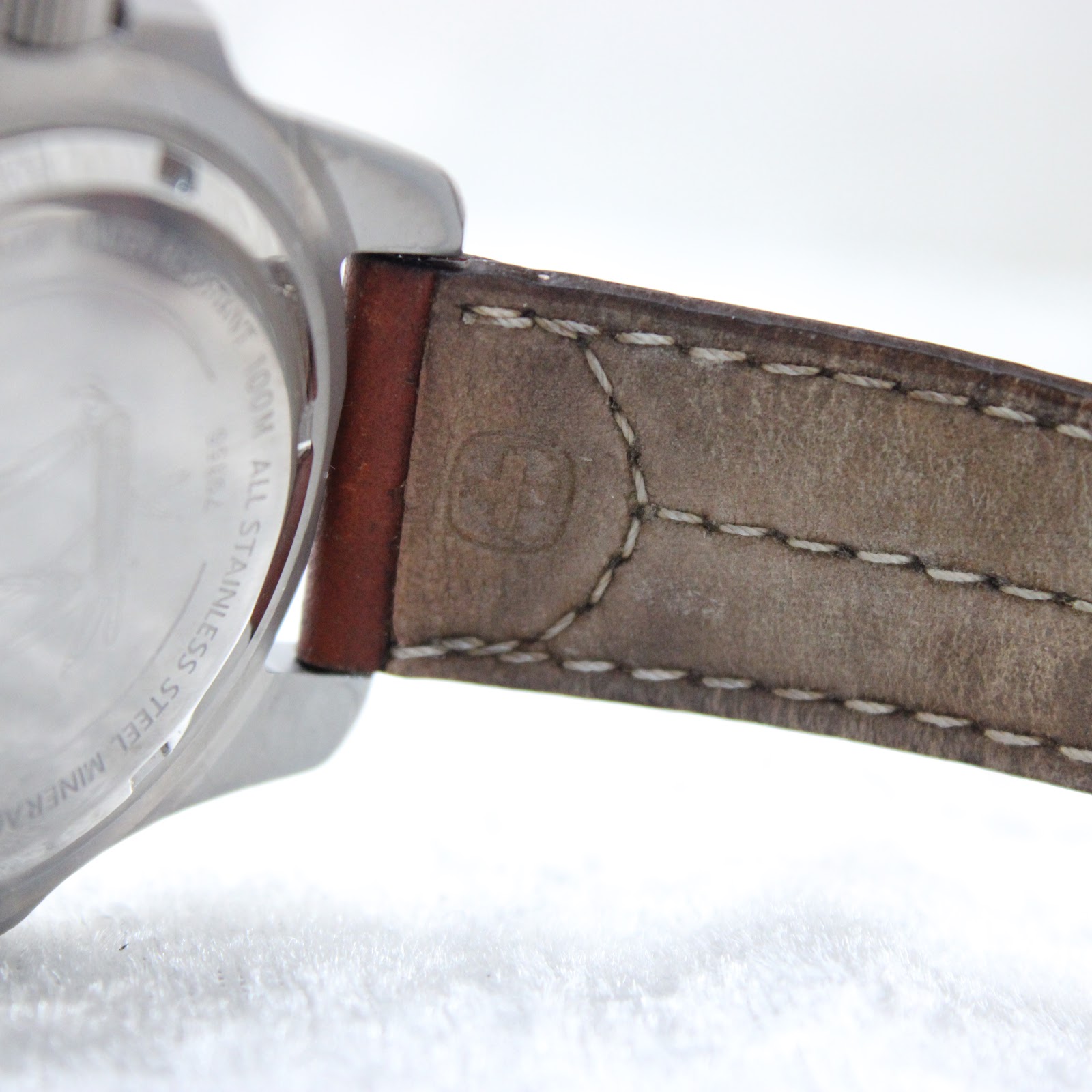 Close-up of the brown leather strap near the lug, showing stitching and a faint embossed logo.