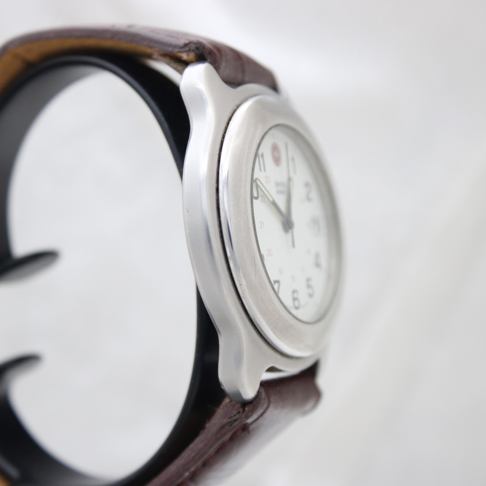 Angled side view of the Swiss Army watch showing the case profile and brown strap.