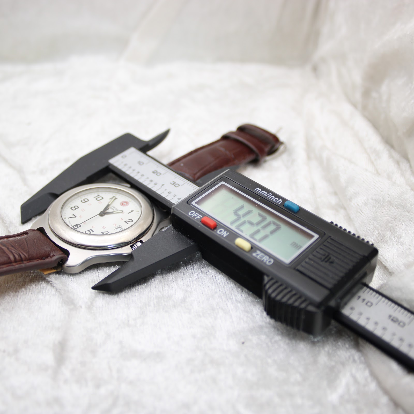 Digital caliper measuring the Swiss Army watch case diameter at precisely 42.0mm.