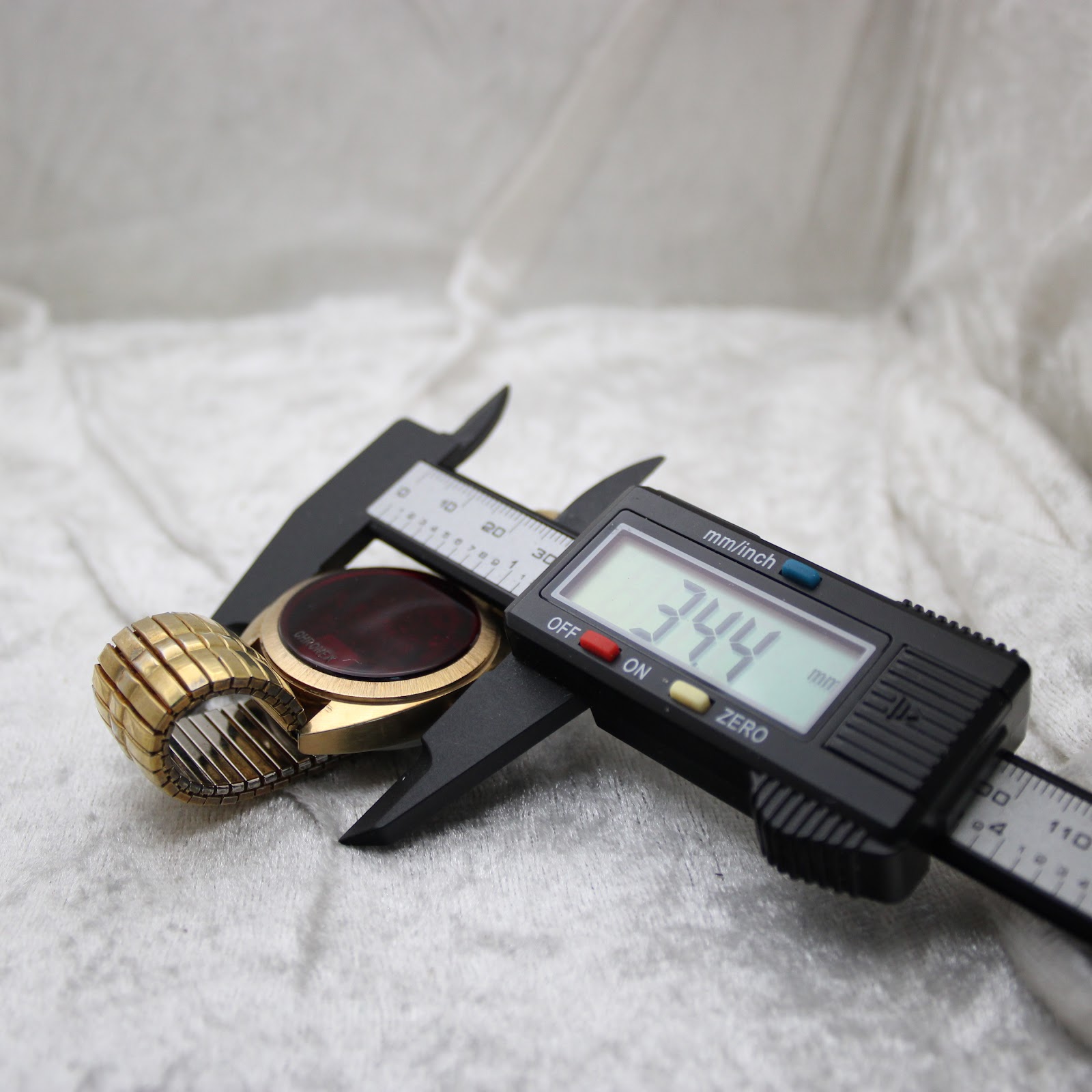 Digital caliper measuring the case diameter of the Chronex watch, with the display clearly reading "34.4 mm".