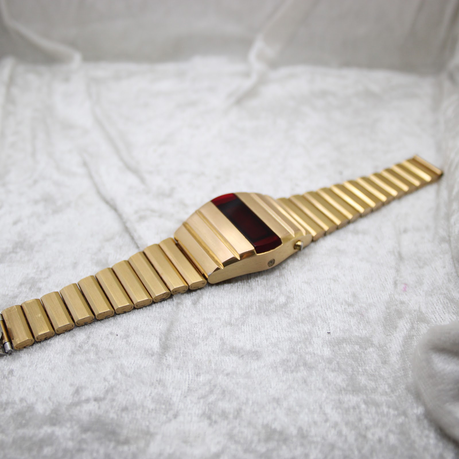 Full-length, slightly angled view of the La Générale LED watch, highlighting the continuous design of the gold-plated integrated bracelet and case.