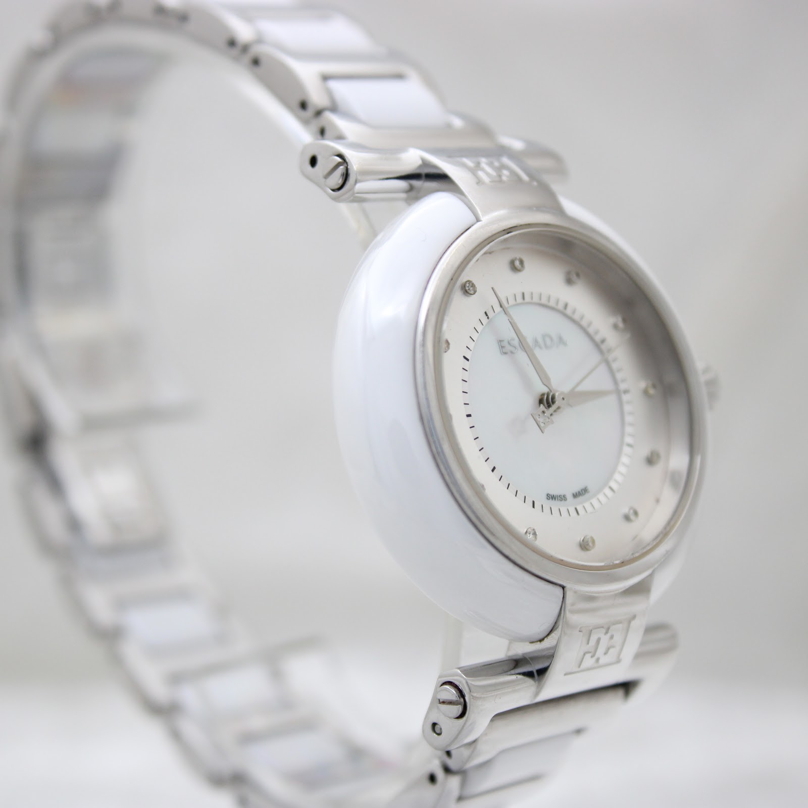Three-quarter front view of the Escada Lauren watch, showcasing the full bracelet and elegant design on a clear stand.