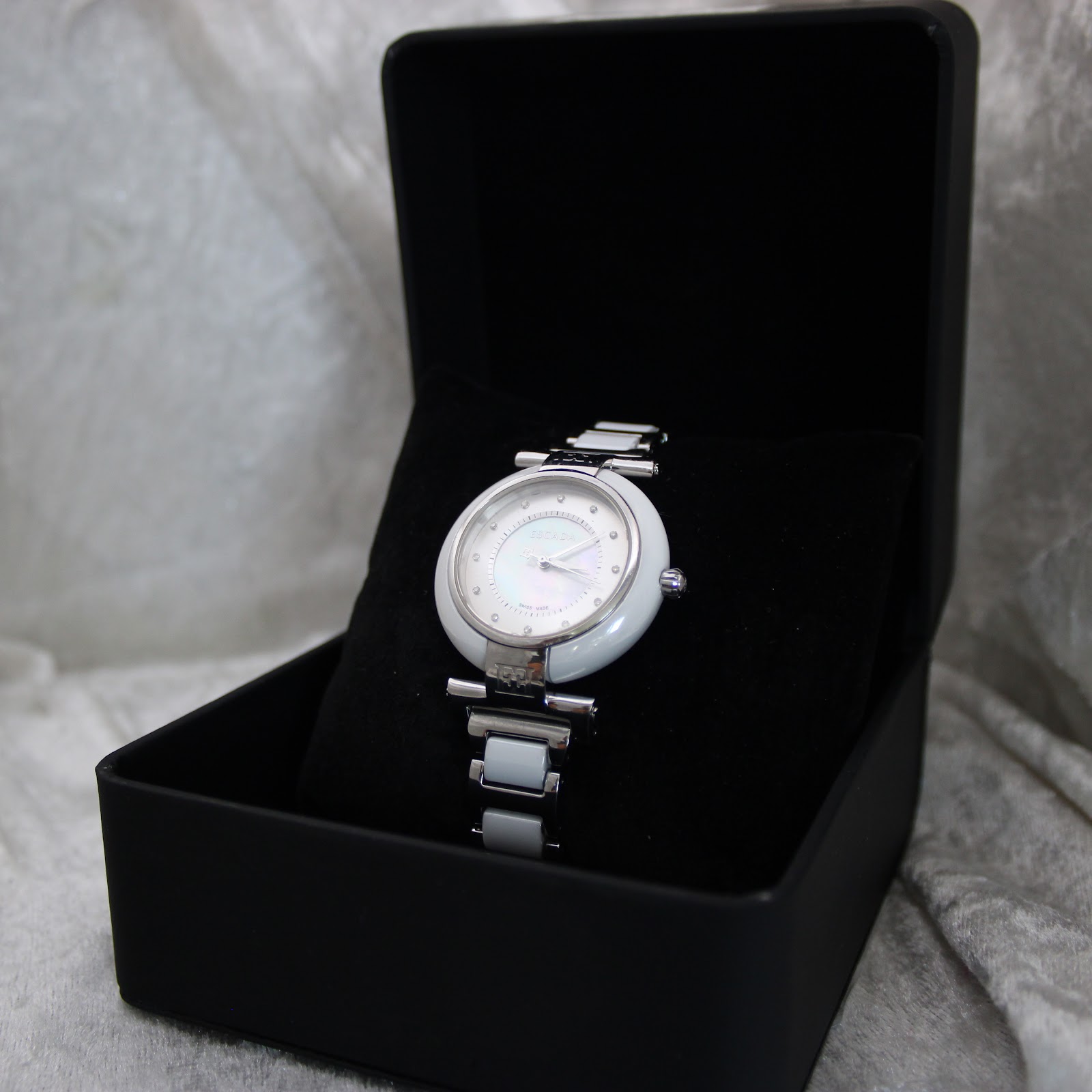The Escada Lauren watch elegantly displayed inside a plain black presentation box with a velvet cushion.