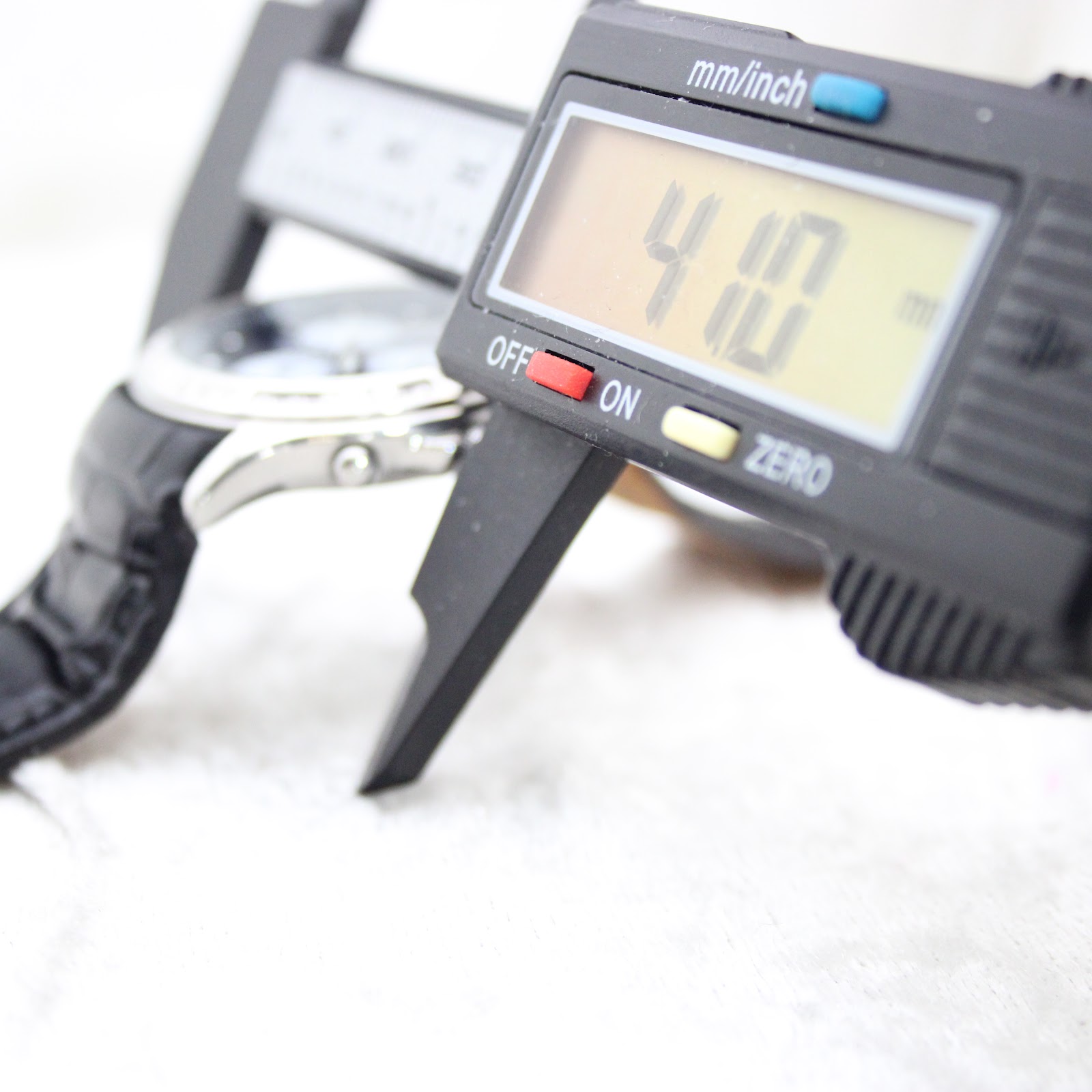 Digital caliper measuring the watch case diameter at 41.0 mm.
