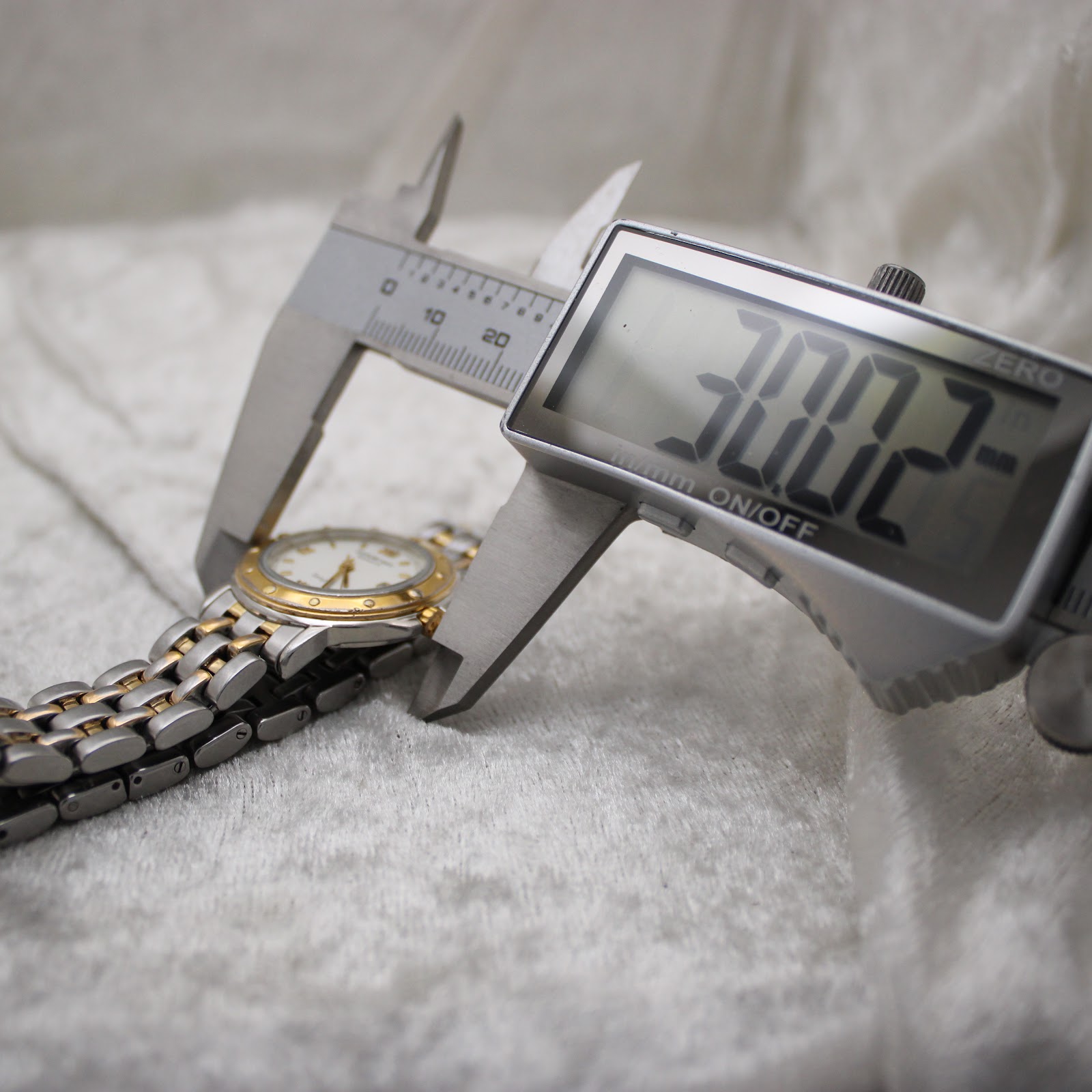 Digital caliper measuring the case diameter of the watch at 30.02mm.