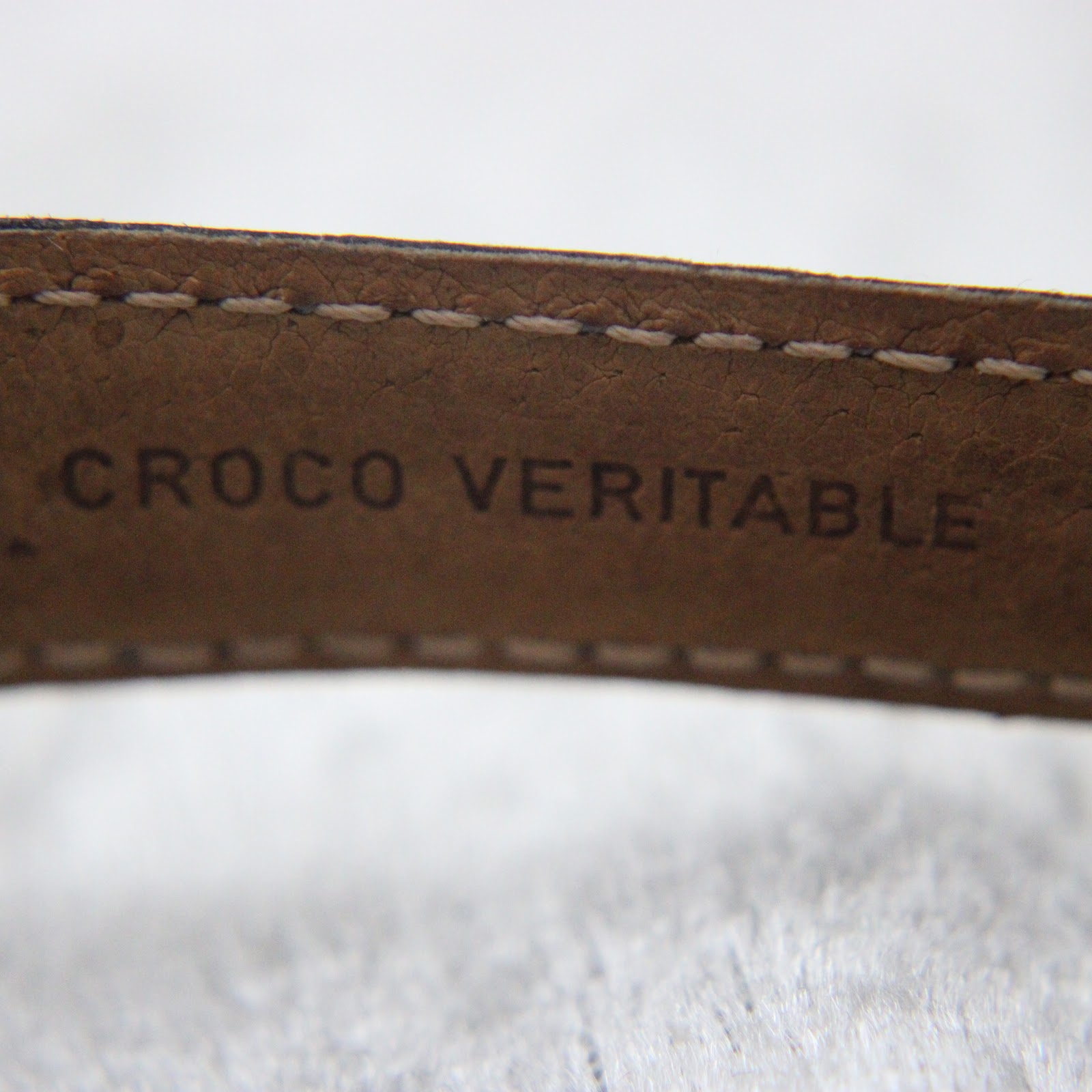 Detailed shot of the strap's underside, showing the embossed 'CROCO VERITABLE' text, indicating genuine crocodile leather.
