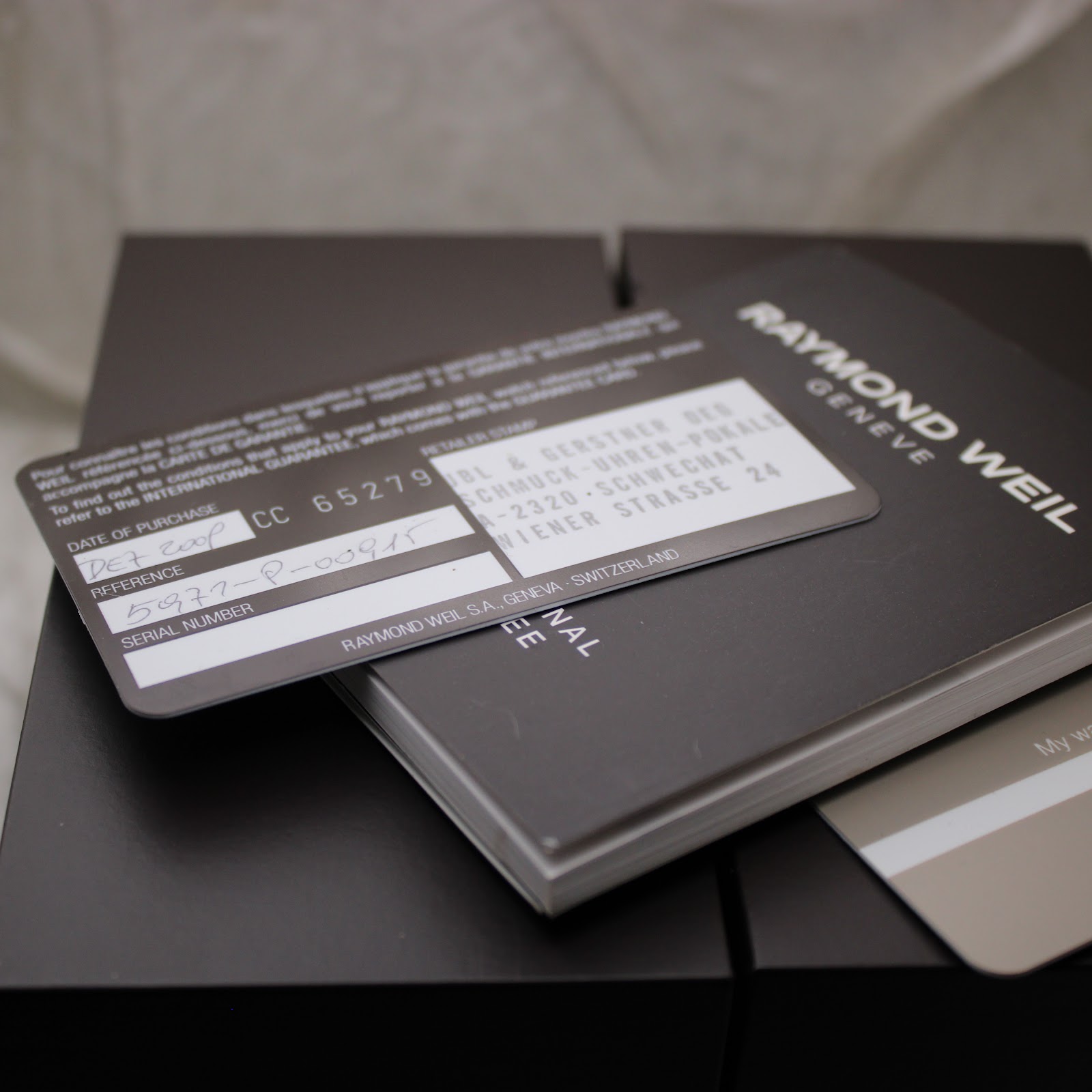 Close-up of the Raymond Weil instruction booklet and authenticity card, showing fields for reference and serial numbers