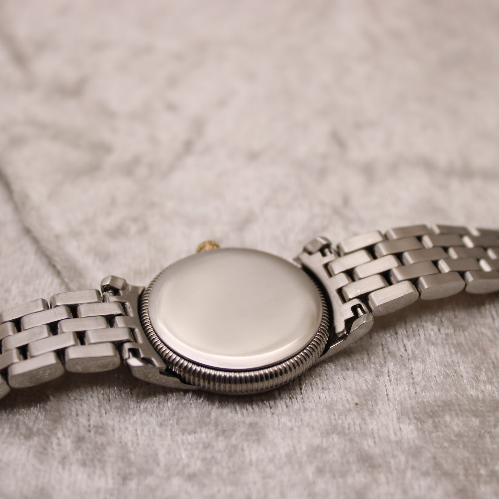 View of the solid stainless steel case back and the two-tone bracelet resting on a soft surface.