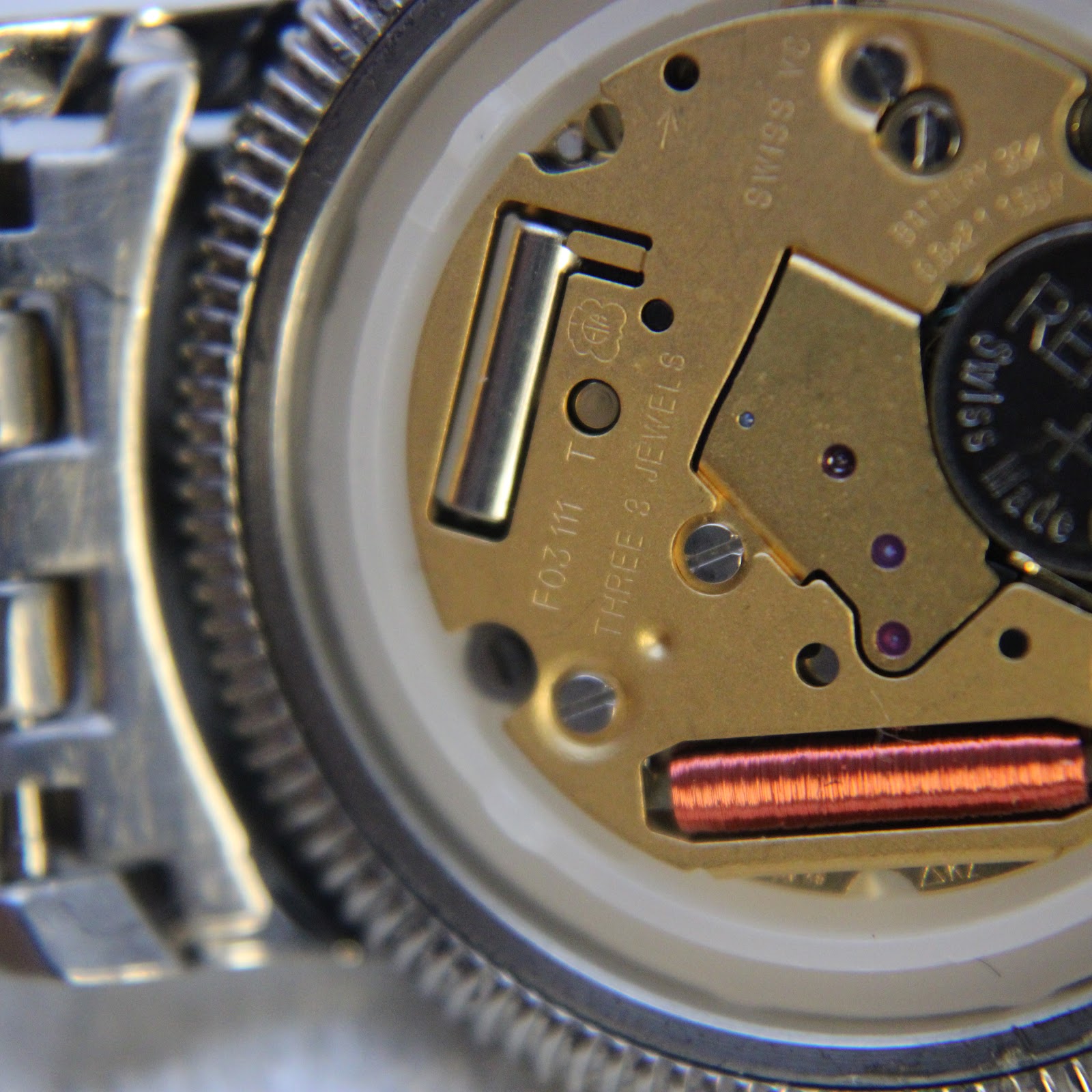 Close-up of the open watch case, revealing the Tissot quartz movement with 'ETA F03 111 THREE 3 JEWELS' visible.