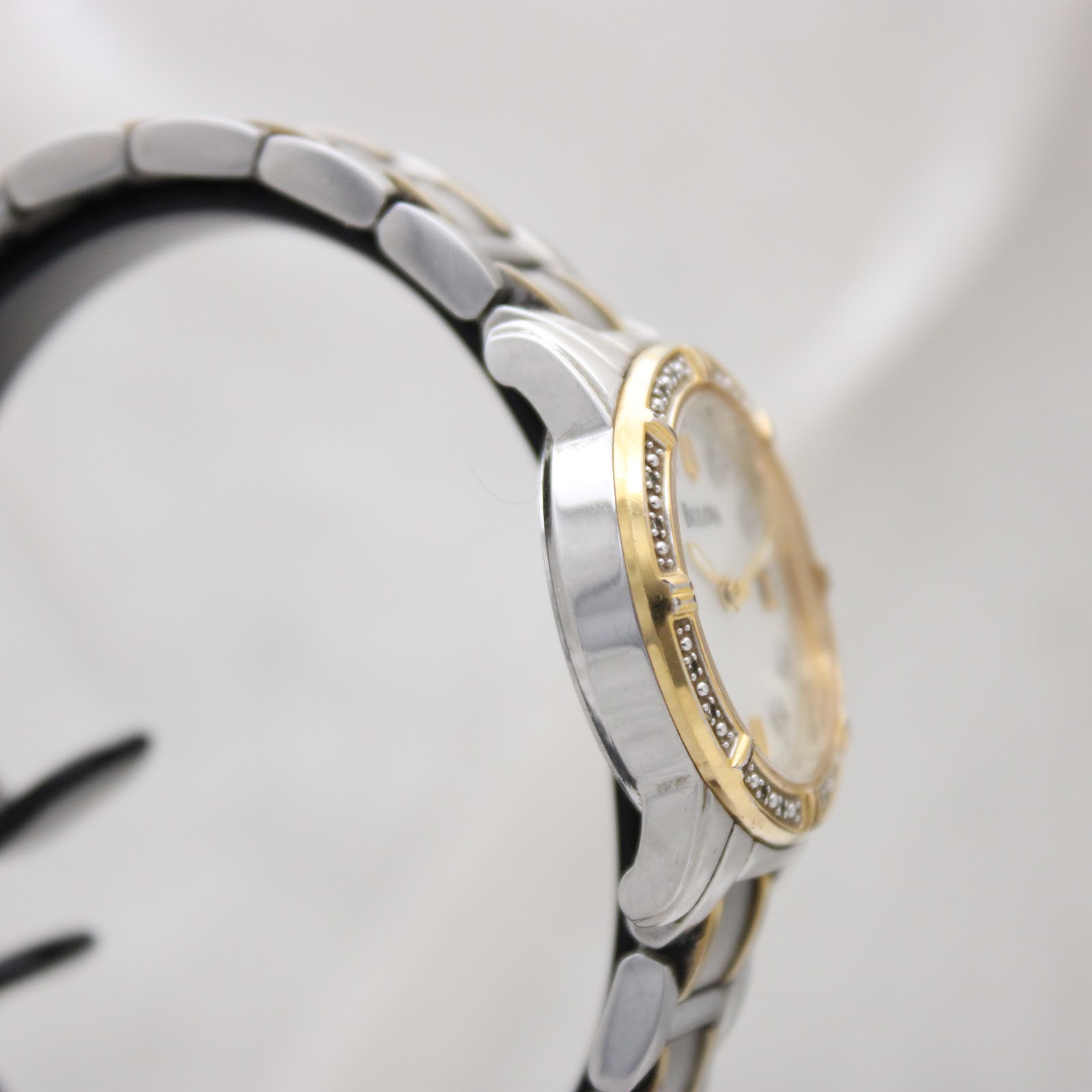 Another side view of the Bulova watch, showing the curved lugs and two-tone bracelet.