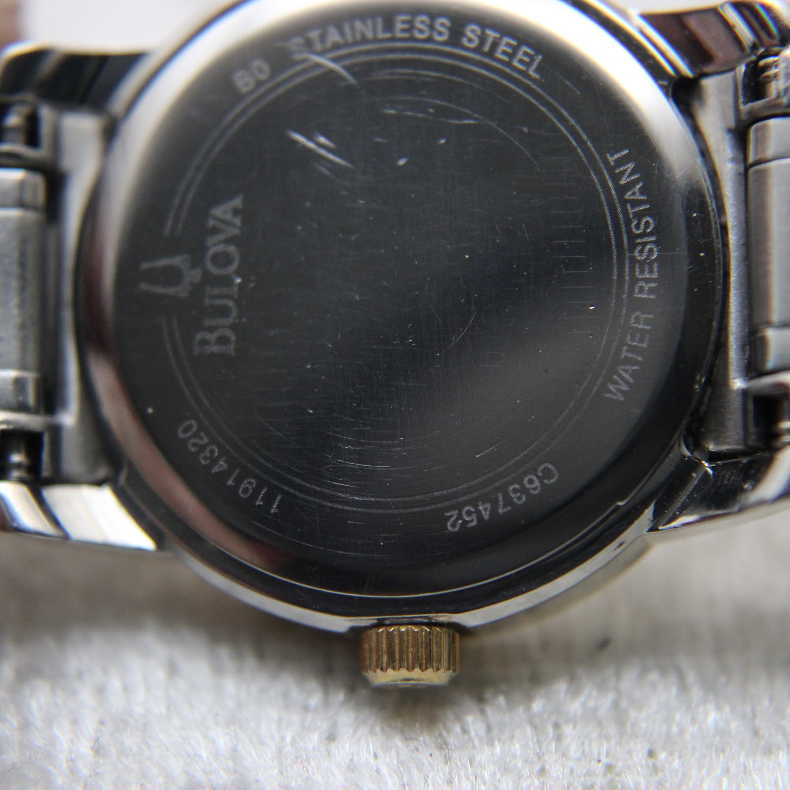 Close-up of the watch case back showing "Bulova", model "C637452", "11914320", "stainless steel" and "water resistant" engravings.