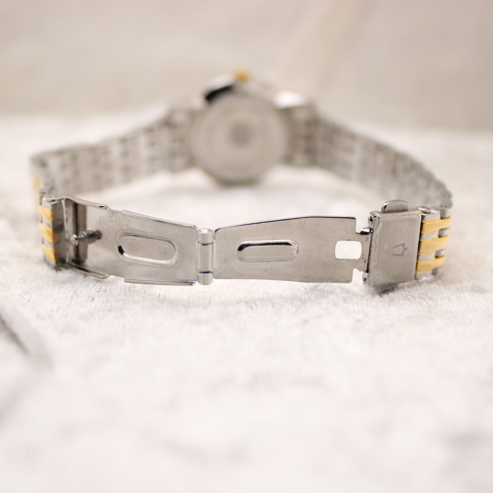 Close-up of the open fold-over clasp on the Bulova two-tone stainless steel bracelet.