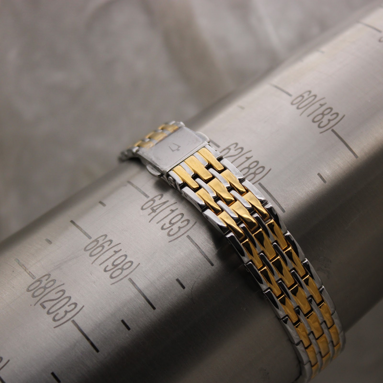 The Bulova two-tone bracelet on a wrist sizing gauge, indicating a circumference of approximately 188mm / 18.8cm.
