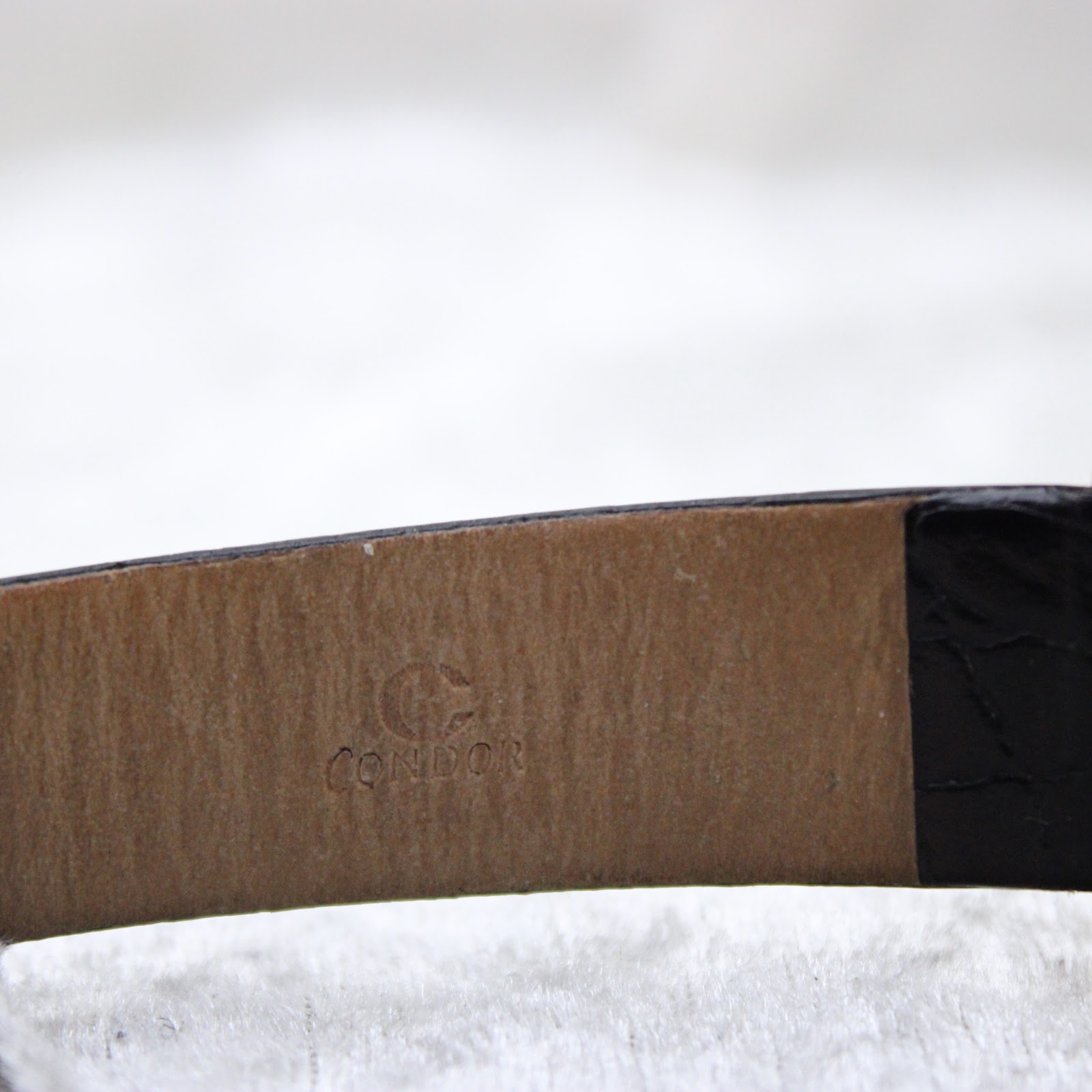 Close-up of the inner side of the black leather strap, showing the "CONDOR" brand embossed mark.