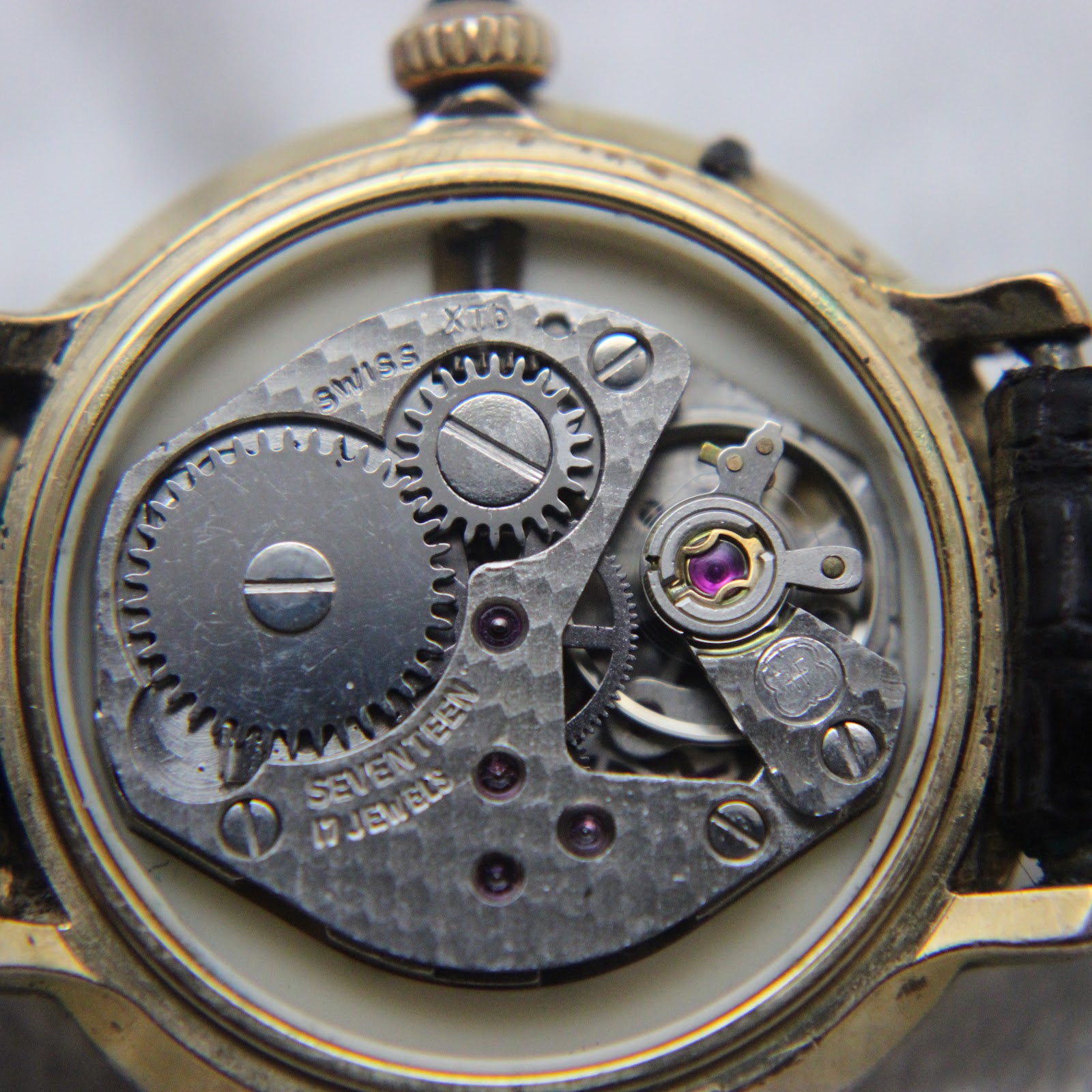 Macro shot of the FHF 96 Swiss manual wind movement, showing gears, balance wheel, and 17 jewels.