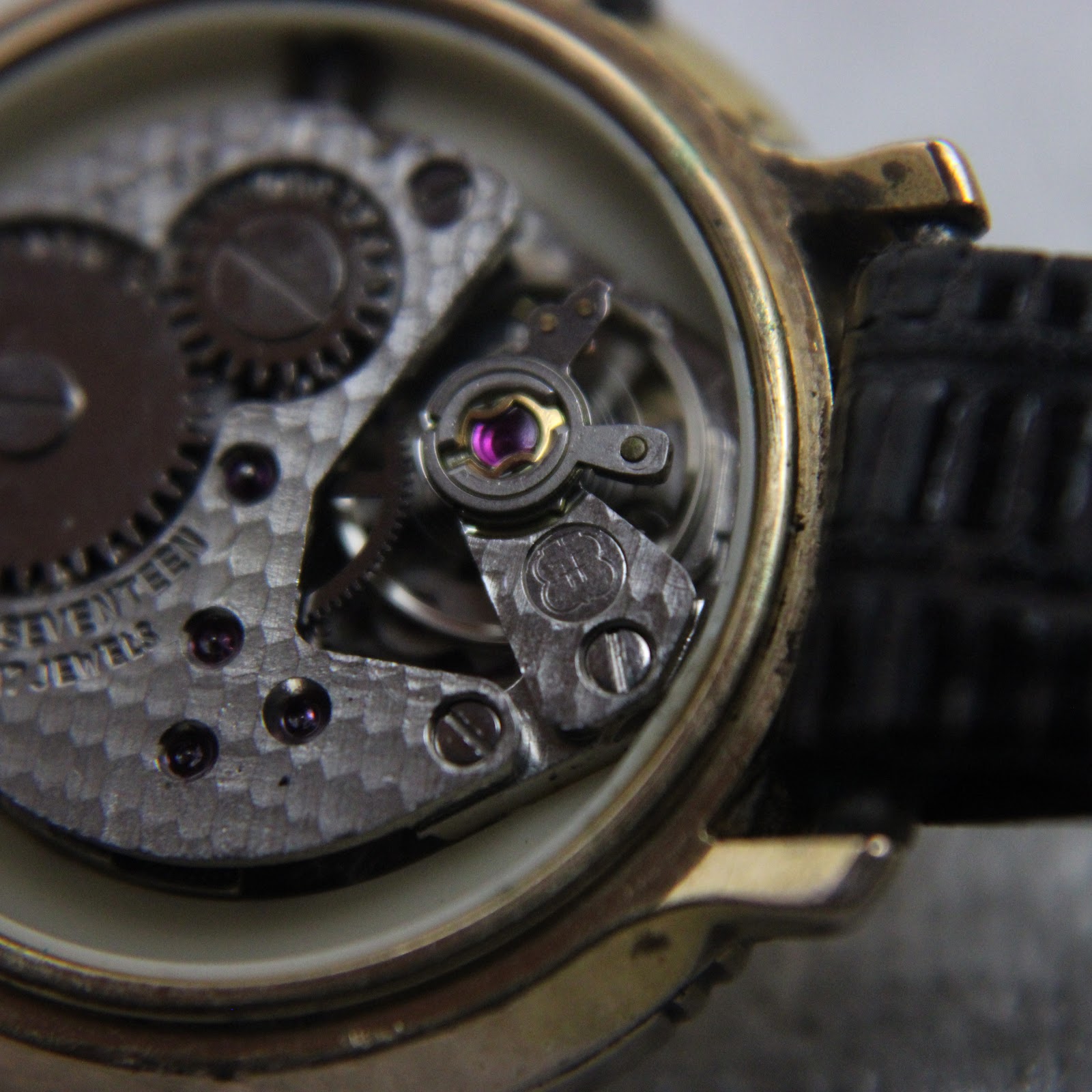 Close-up of the watch movement, highlighting the balance wheel and jewels, showing "SEVENTEEN 17 JEWELS".