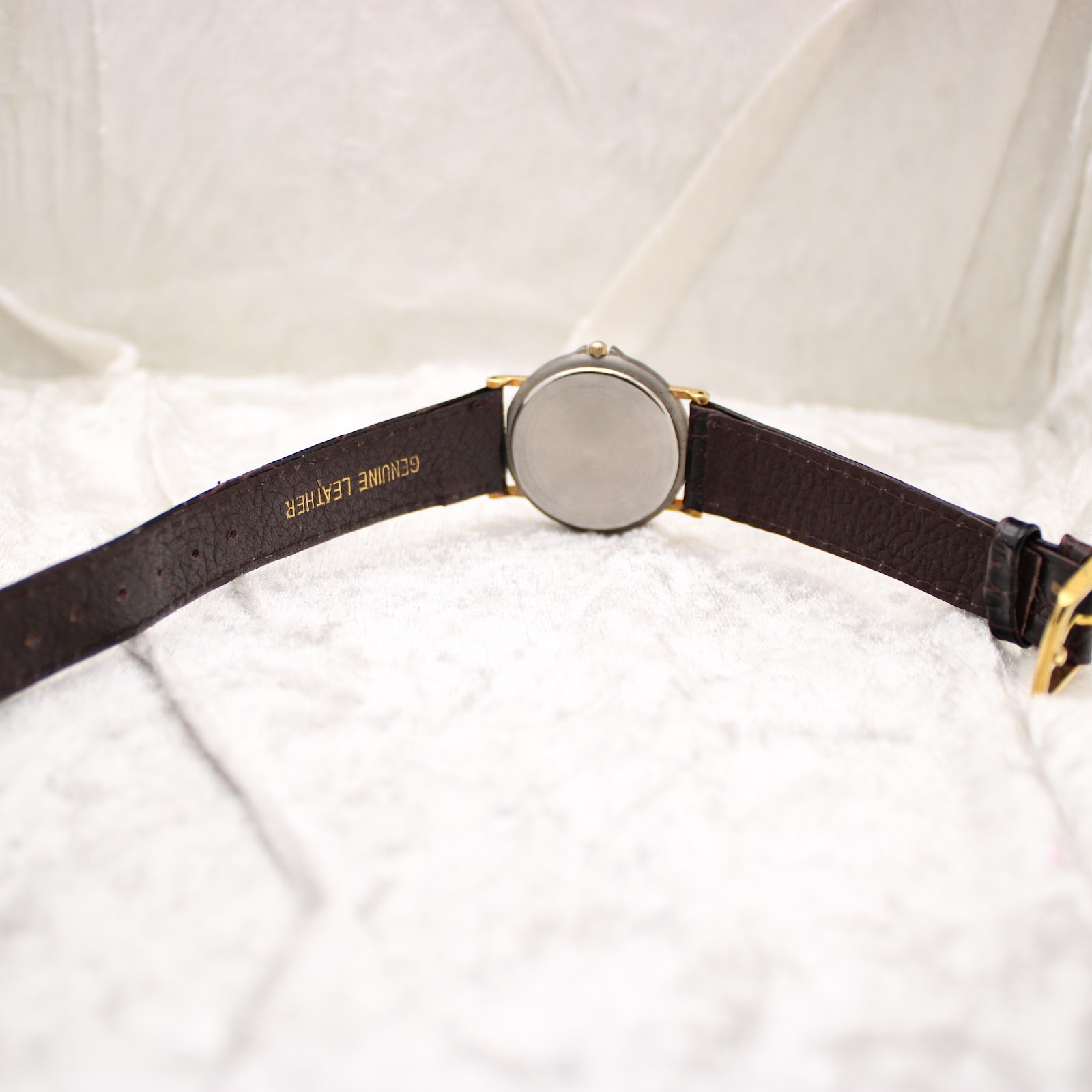 Rear view of the Montine watch, showing the plain case back and the 'GENUINE LEATHER' text on the strap.