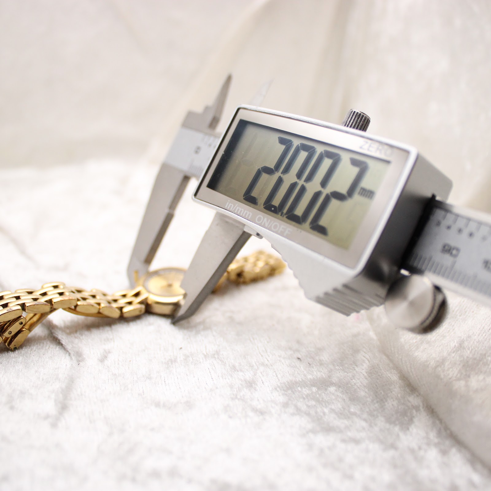 Digital caliper measuring the case diameter of the watch, displaying 20.02mm.