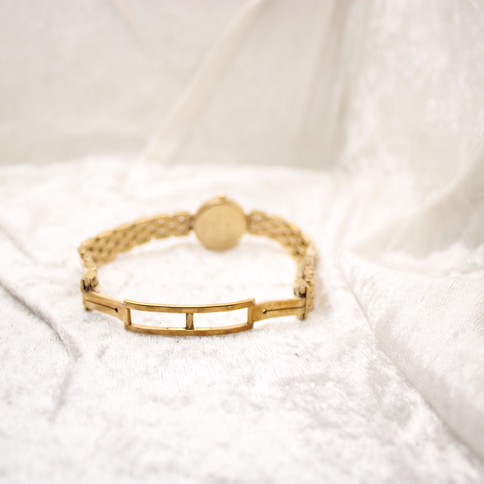 Rear view of the gold electroplated bracelet, showing the fold-over clasp mechanism.
