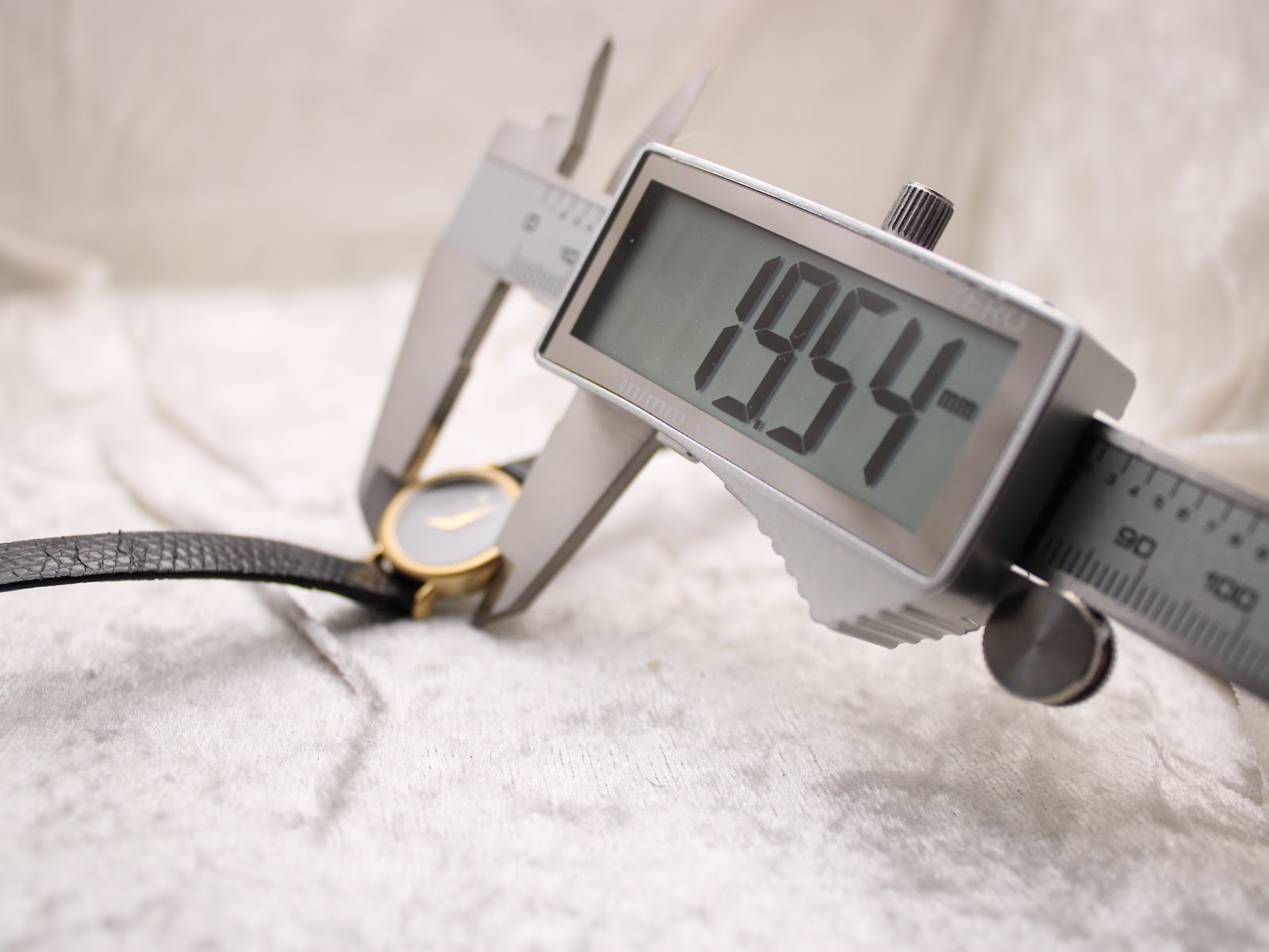 Digital caliper measuring the case diameter of the watch, displaying 19.54mm.