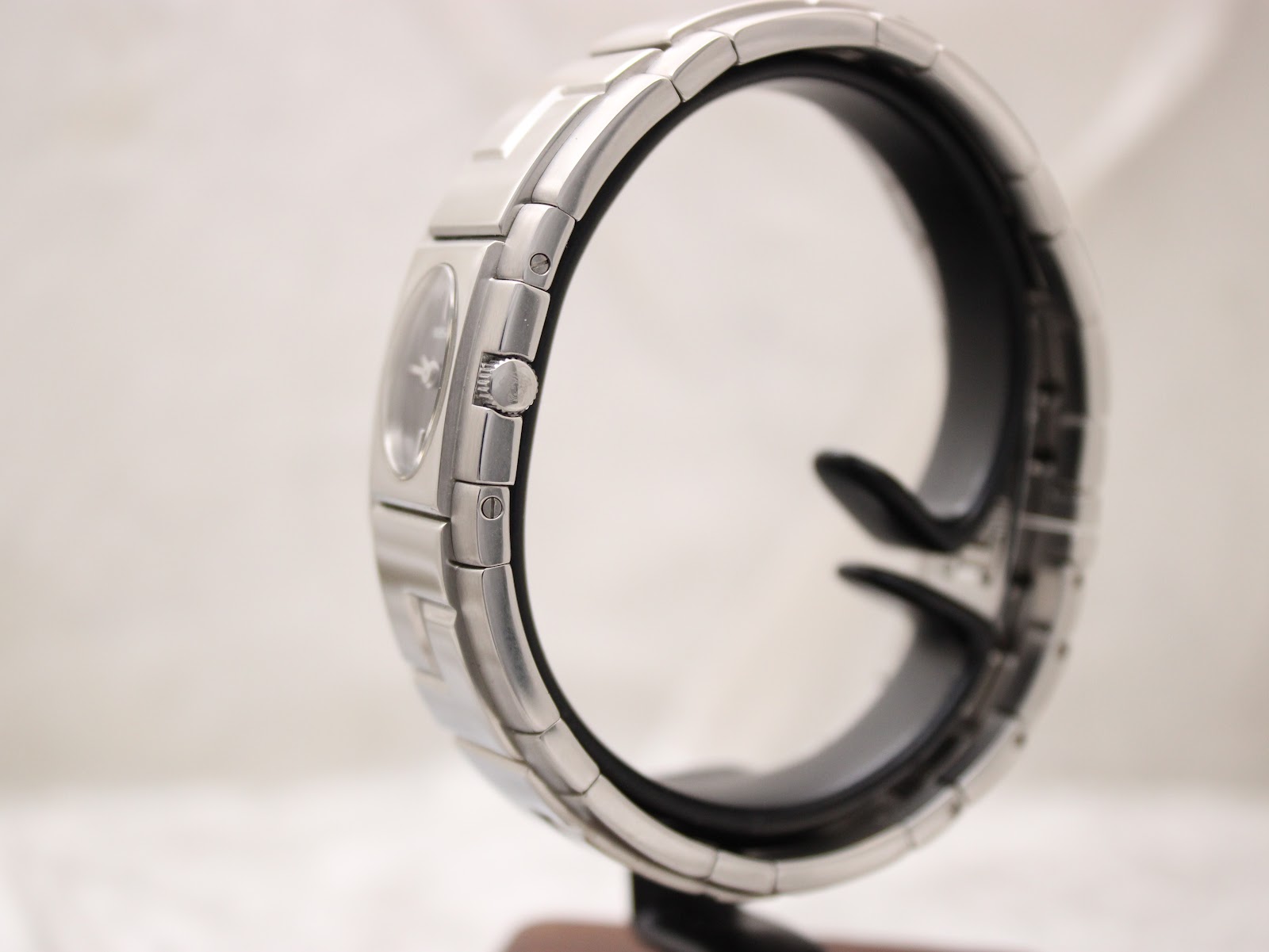 Side view of the Versace ESQ99 watch on a display stand, showing the signed crown.