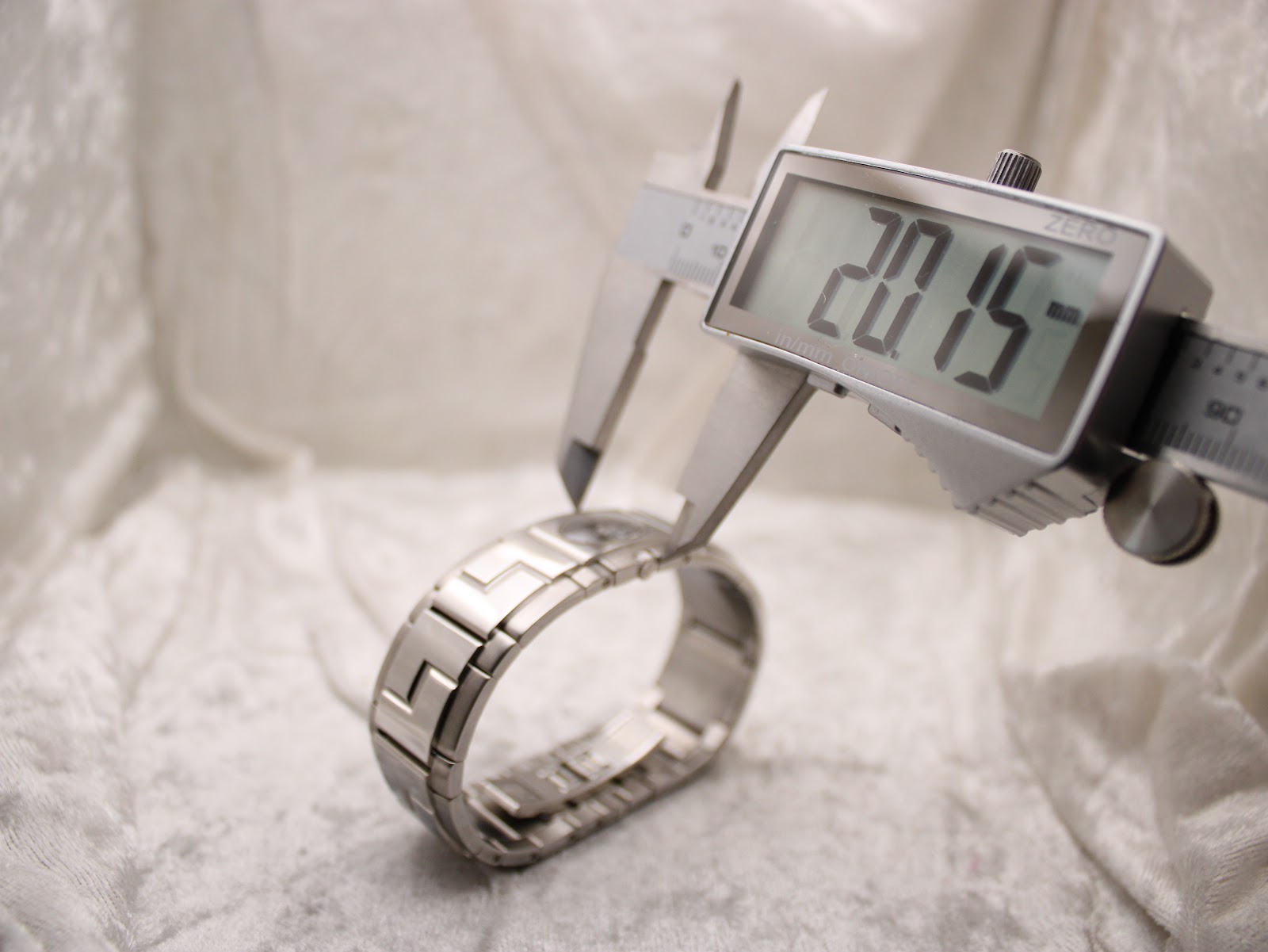 Digital caliper measuring the width of the watch case, displaying a precise reading of 20.15mm.