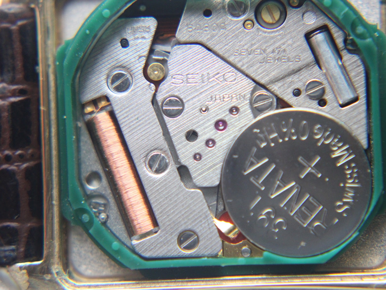 Close-up of the Seiko 6430 quartz movement inside the watch, displaying 7 jewels and a Renata battery.