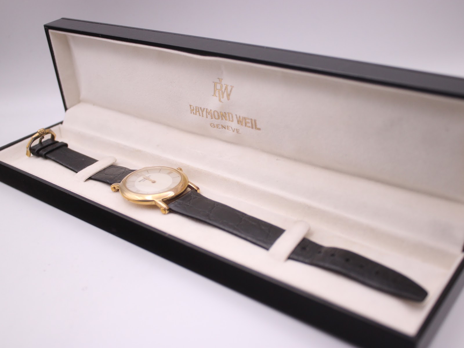 The Raymond Weil 9833 watch resting inside its original black Raymond Weil presentation box with cream lining.