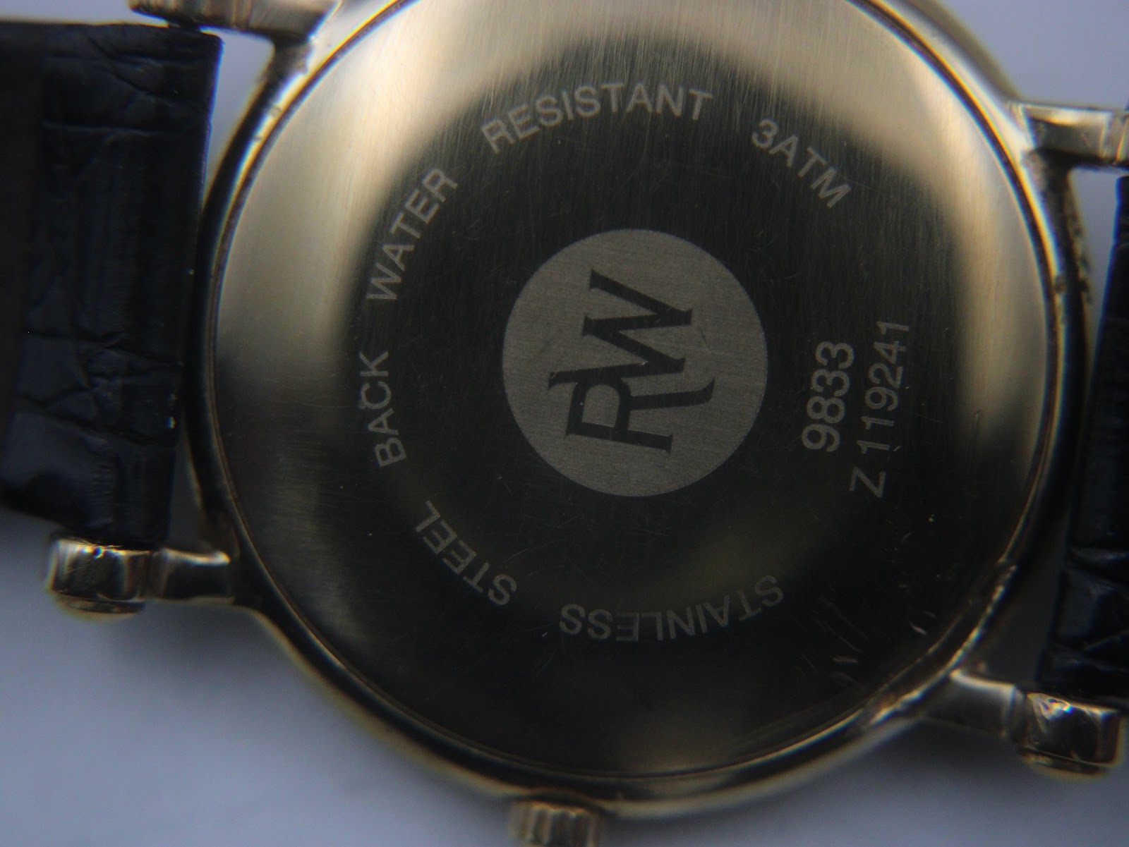 Close-up of the stainless steel case back of the Raymond Weil 9833, showing model number, serial, and water resistance.
