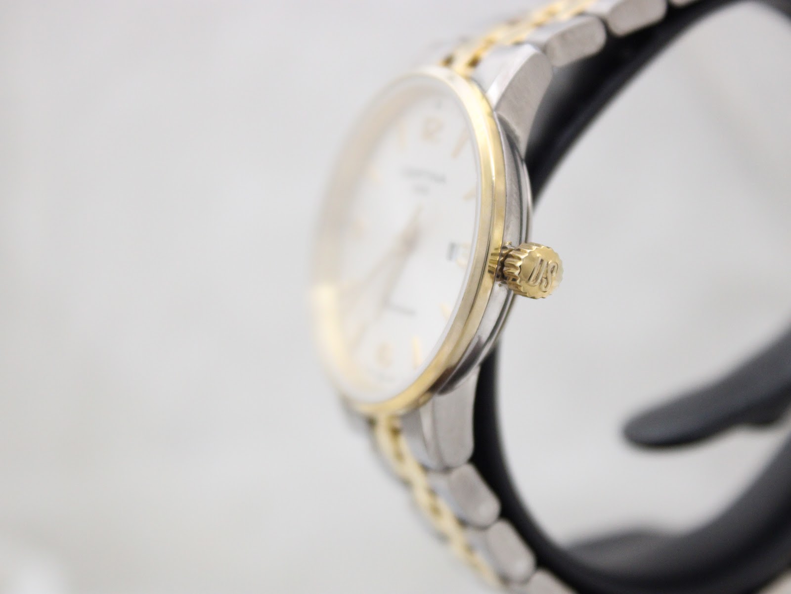 Side profile of the Certina DS Caimano watch, highlighting the signed "DS" gold-tone crown.