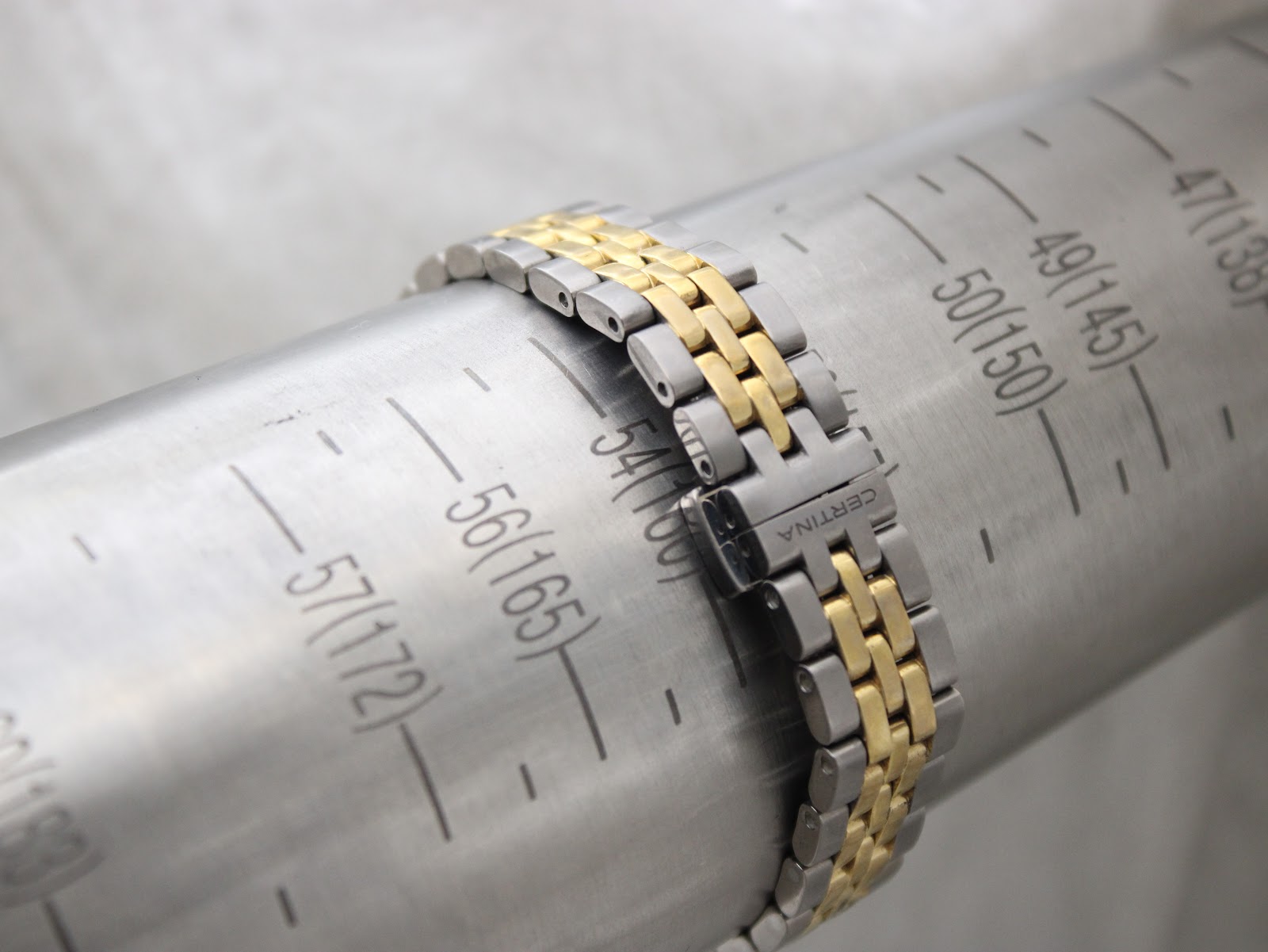 The Certina DS Caimano's two-tone bracelet wrapped around a wrist sizing gauge, indicating a maximum wrist fit of 165mm.