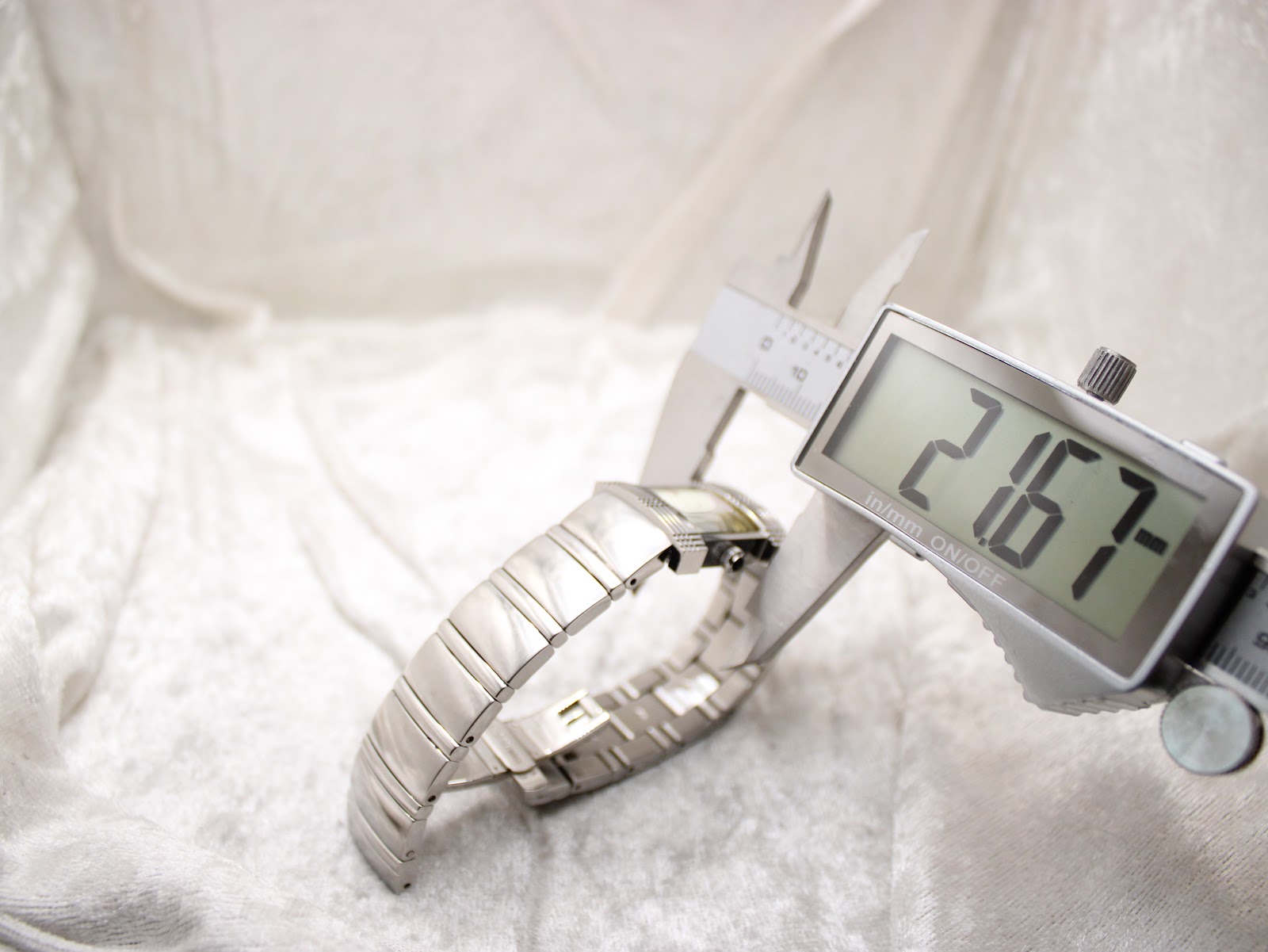 Digital caliper measuring the width of the Burberry watch case (excluding crown), displaying a reading of 21.67mm.