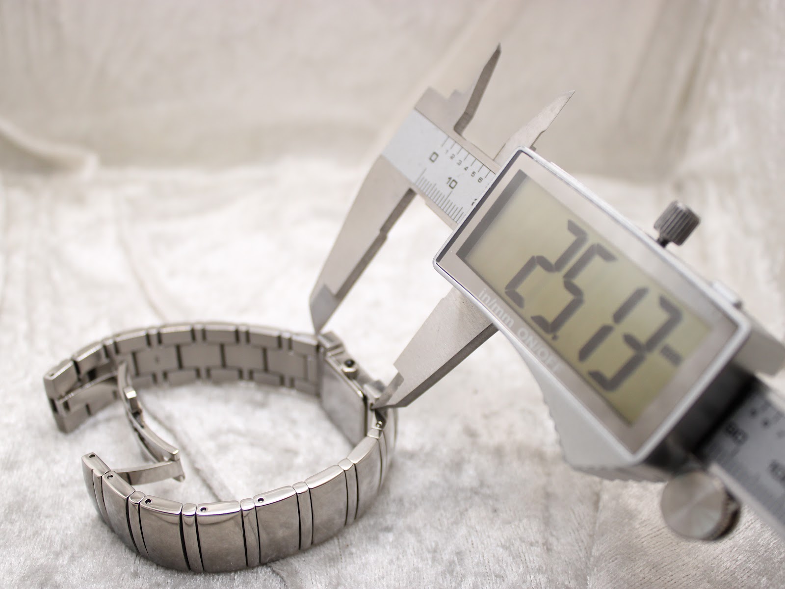 Digital caliper measuring another dimension of the watch bracelet, displaying a reading of 25.13mm.