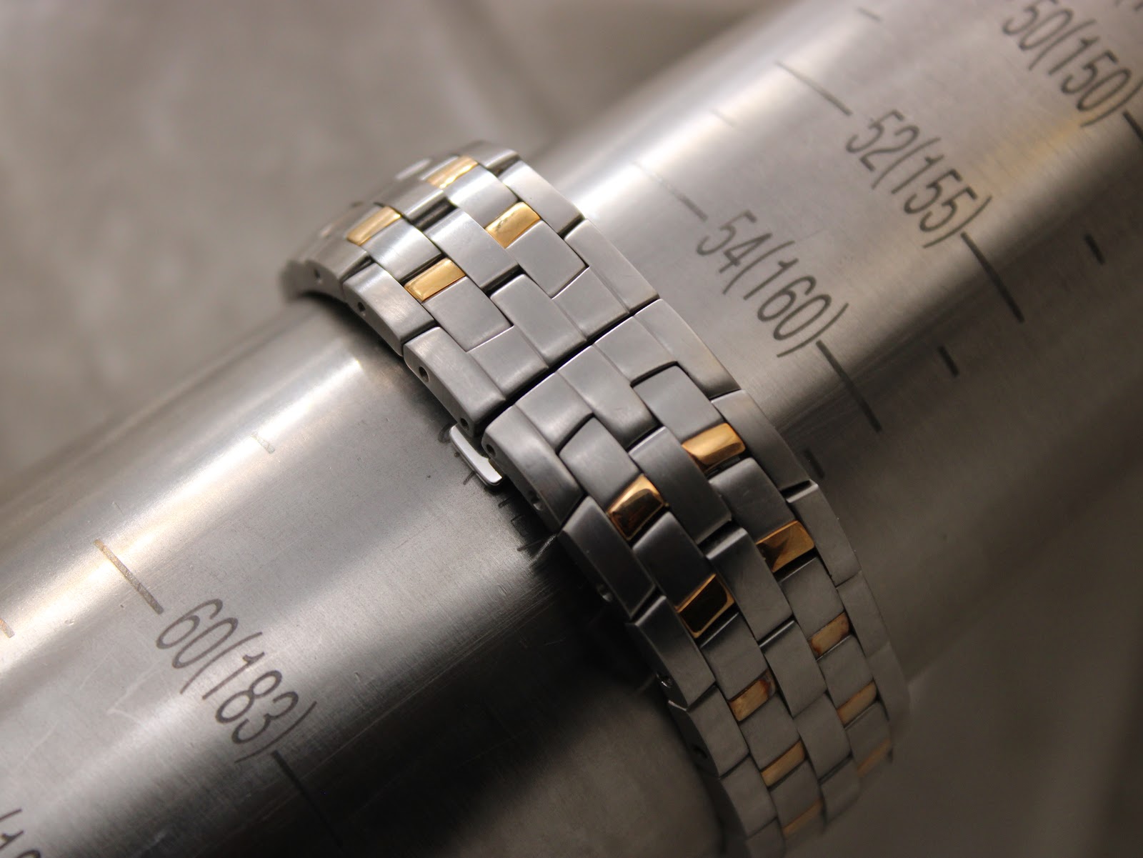 The two-tone bracelet wrapped around a wrist sizing gauge, indicating a circumference of approximately 170mm.