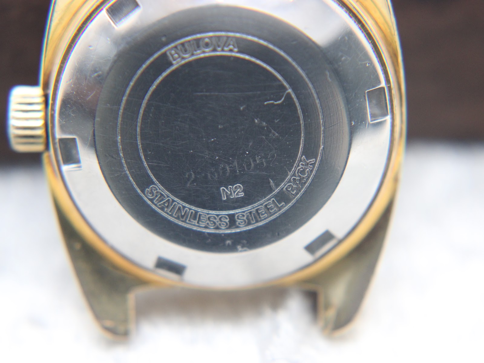 Close-up of the stainless steel case back of the Bulova watch, showing "BULOVA", serial number "2-601052", "N2", and "STAINLESS STEEL BACK".