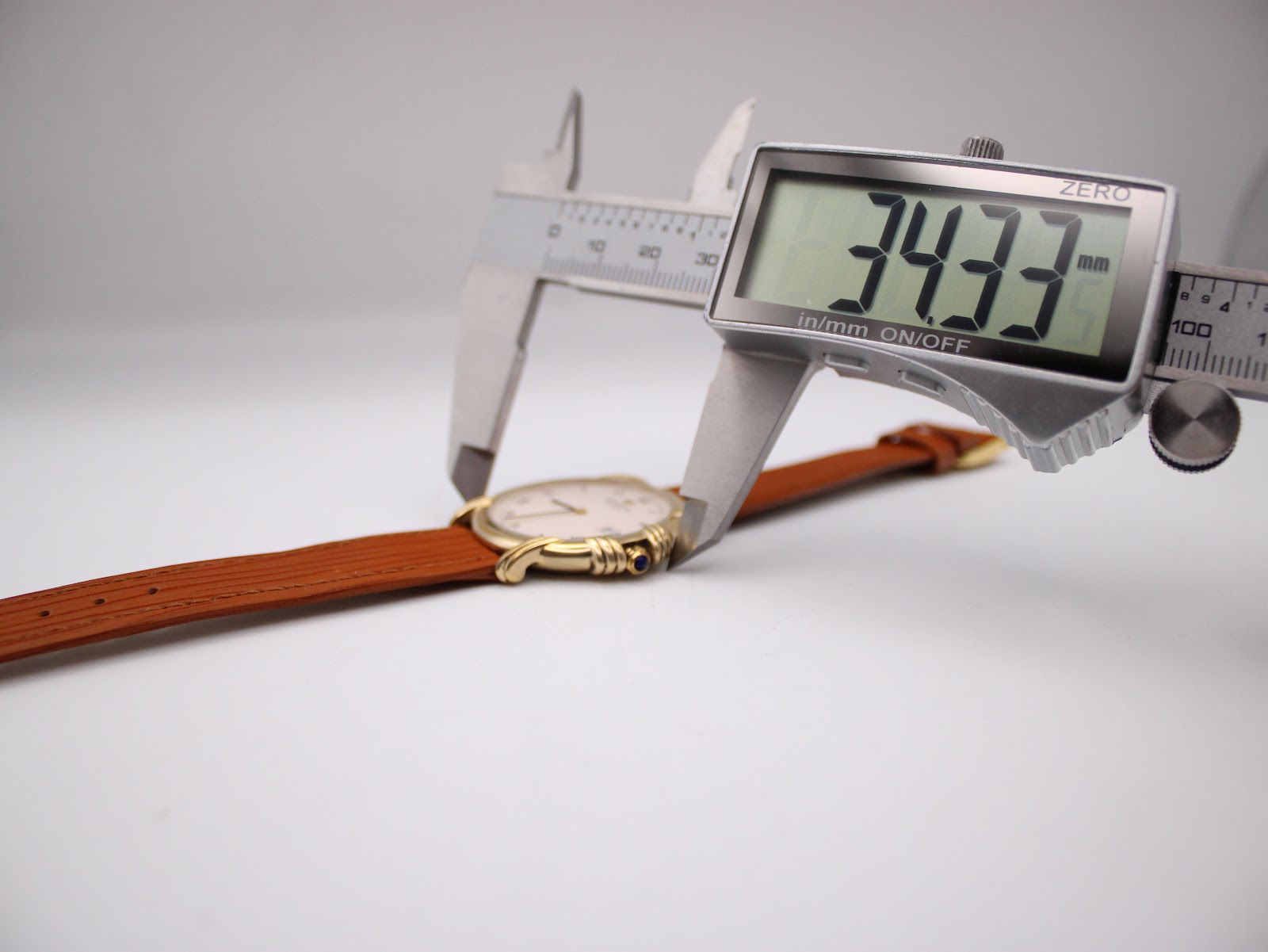Digital caliper measuring the case diameter of the Raymond Weil watch, displaying 34.33mm.